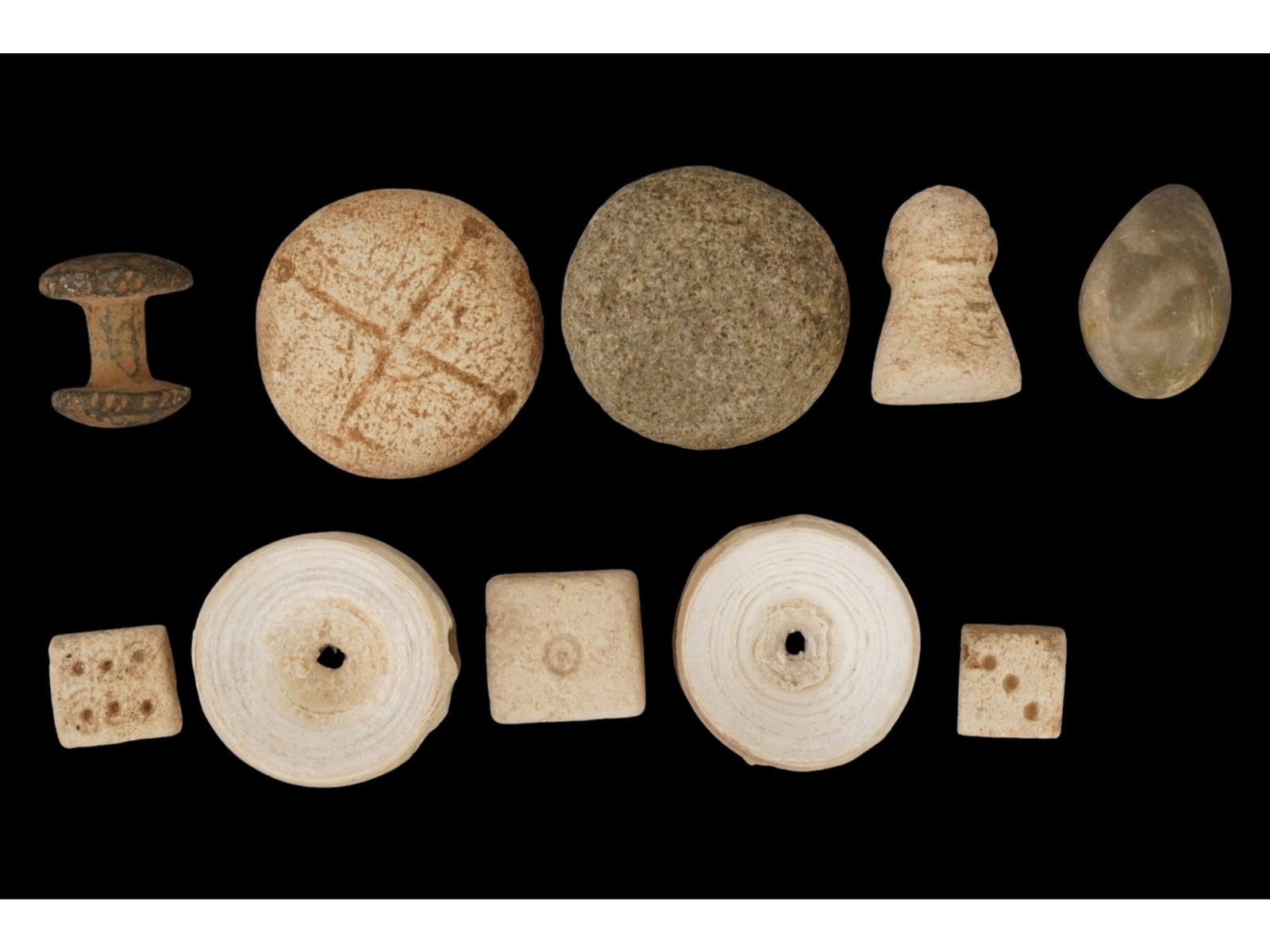 14- GROUP OF ANCIENT GAMING PIECES 1ST MILLENIUM - ROMAN PERIOD: A collection of ancient carved stone gaming pieces. The wares are made in various sizes and shapes including circular, oval, rectangular and others. Several are adorned with openings and engravings. C
