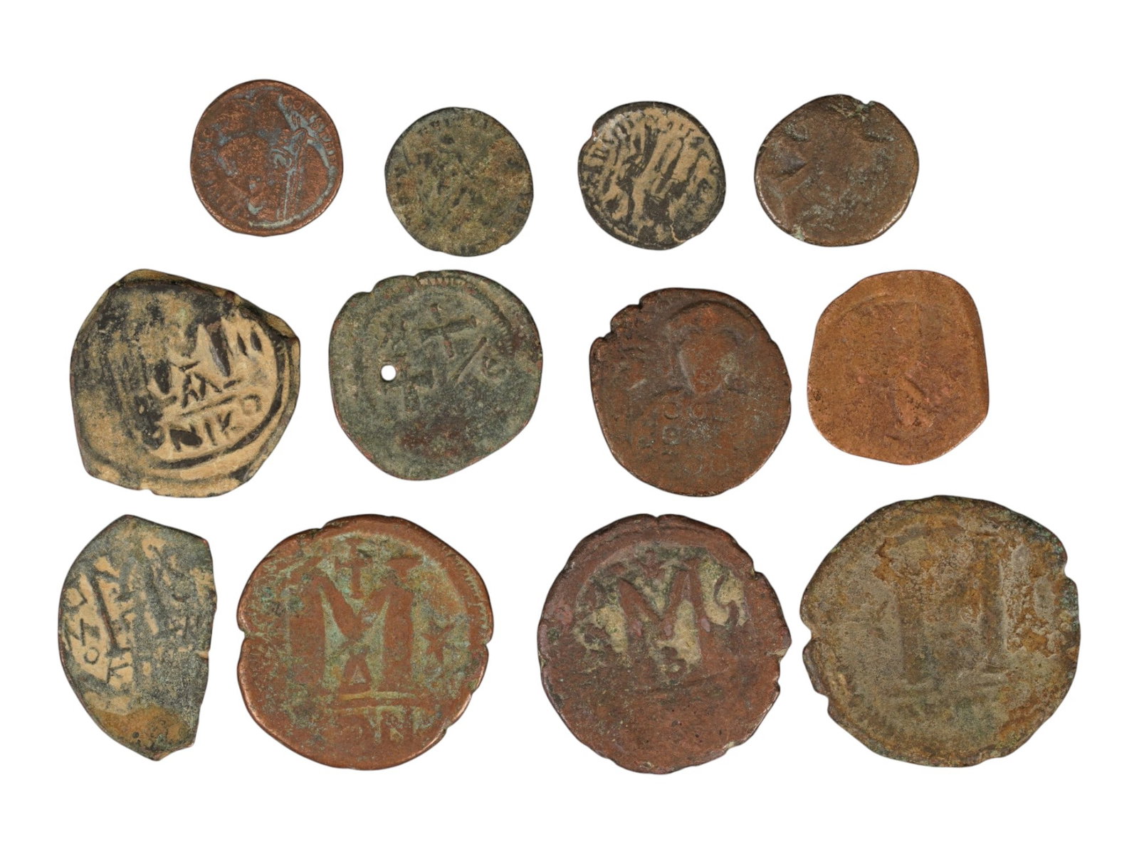 ANCIENT BRONZE MIXED BYZANTINE ROMAN COINS 100 TO 600 AD: A lot of twelve ancient bronze coins spanning the Roman Imperial and Byzantine periods, dating approximately from 100 to 600 AD. The lot includes several Byzantine folles, smaller Roman bronze issues.