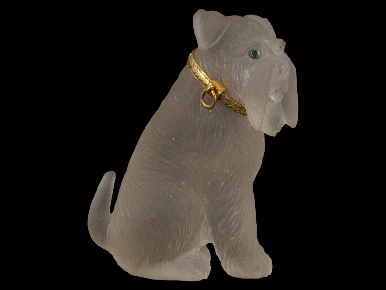 RUSSIAN ROCK CRYSTAL FIGURINE GOLD COLLAR SAPPHIRE EYES: A Russian carved Rock Crystal figurine depicting a seated terrier dog. The animal is adorned with a chased gold collar featuring a foliate laurel motif and is set with two sapphire cabochon eyes