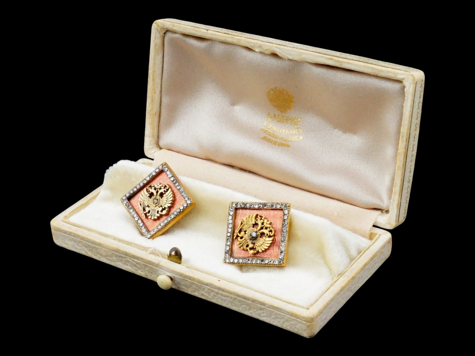 RUSSIAN SILVER ENAMEL DIAMOND IMPERIAL CUFFLINKS: A pair of Russian Imperial Presentation gilt silver whale-back cufflinks. The front parts represent the Imperial eagle on guilloche enamel ground encompassed with diamonds. The backing is also set wit