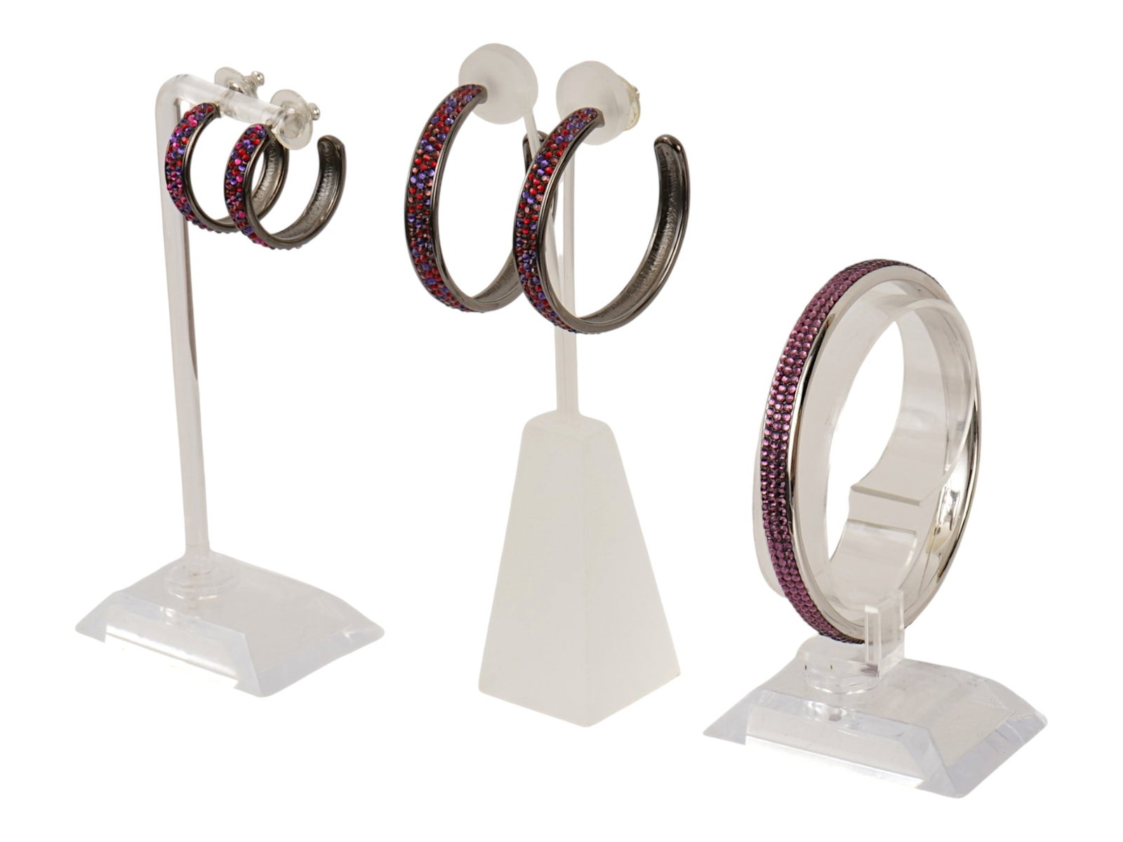 JUDITH LEIBER AMERICAN JEWELRY SET EARRINGS BRACELET: A jewelry set from the American luxury brand Judith Leiber from the vintage Paparazzi collection. The lot includes a thin, rigid bangle bracelet made of silver colored jewelry alloy, decorated with a 