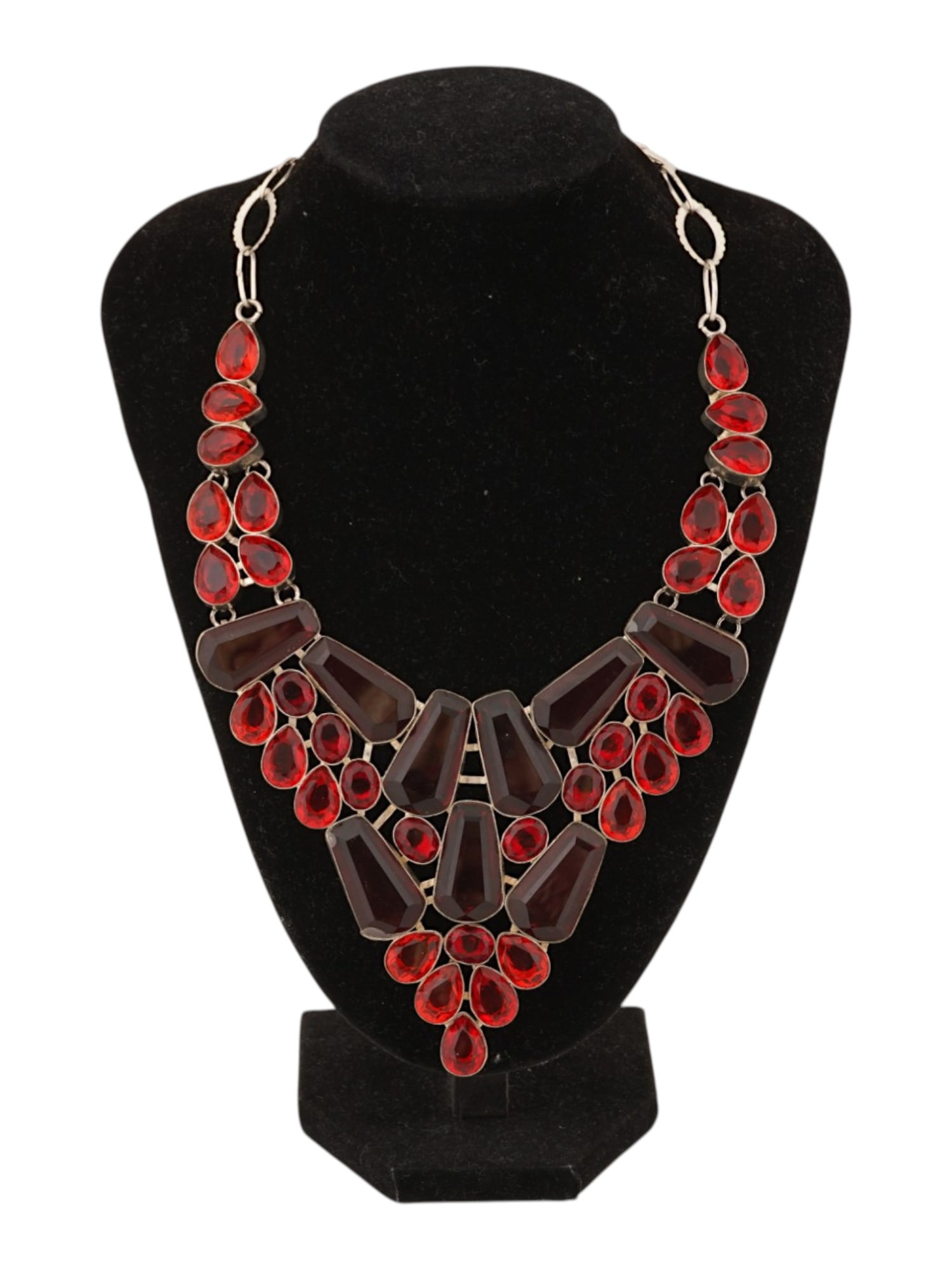 VINTAGE STERLING SILVER BIB NECKLACE W RED STONES: A vintage handcrafted sterling silver bib necklace featuring an arrangement of faceted red stones. The bold design showcases richly colored gemstones set within a sterling silver framework for