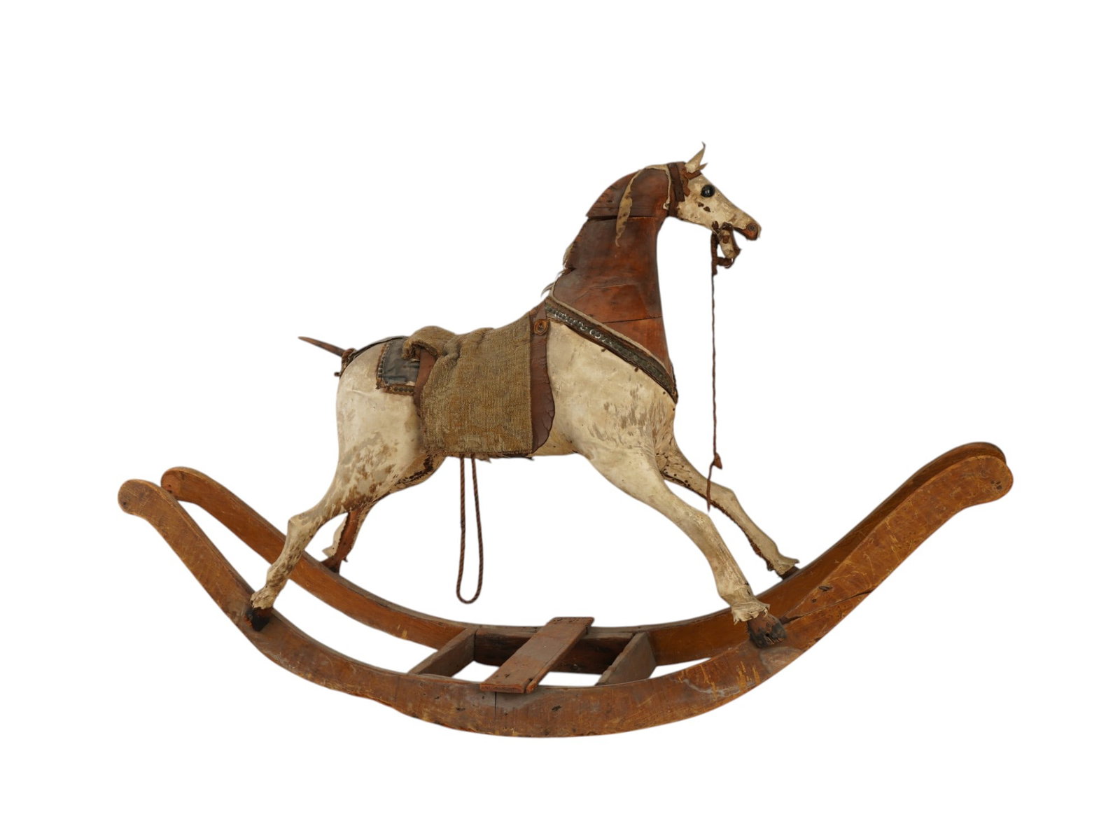 HAND CARVED AND PAINTED WOOD ROCKING HORSE TOY: An antique rocking horse featuring a hand carved wooden body mounted on traditional curved bow rockers. The figure is finished in a distressed polychrome paint, suggesting a dapple grey or cream