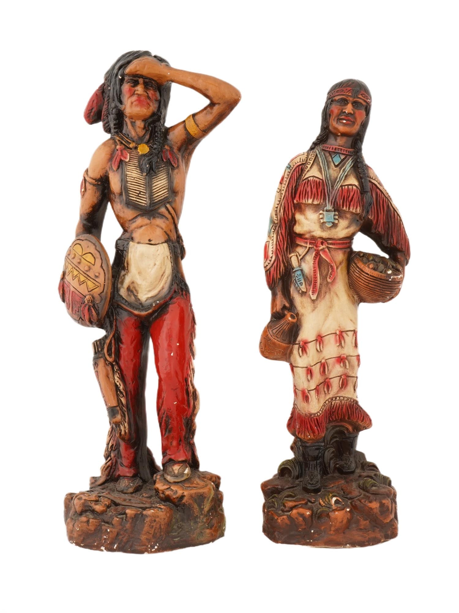 LARGE VINTAGE COMPOSITE NATIVE AMERICAN SCULPTURES: A pair of large vintage hand painted composite Native American sculptures. The sculptures depict Native Americans, a man and a woman, in dynamic poses. They are raised on a base with protective