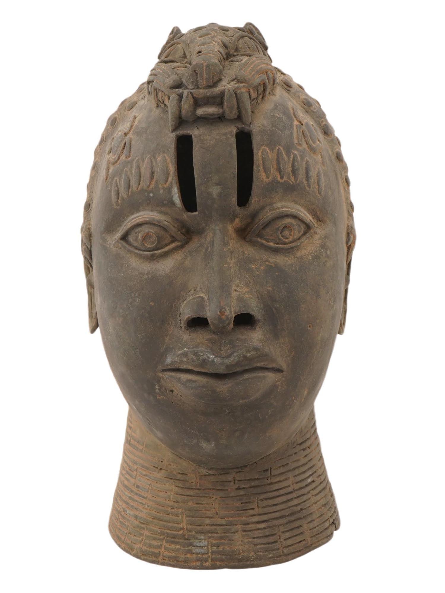 WEST AFRICAN BENIN KING OBA BRONZE HEAD: A West African bronze head mask of an Oba from the Kingdom of Benin. These heads were created to be placed on ancestral altars in the royal palace to honor deceased kings. The figure on top is a leopa