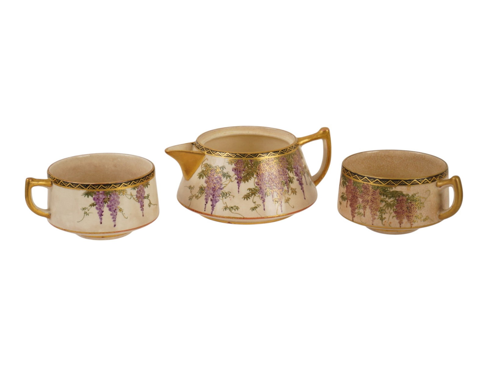 ANTIQUE JAPANESE SATSUMA WISTERIA STACKING TEA SET: An antique Japanese Satsuma stacking tea set decorated with finely hand-painted purple and pink wisteria flowers, green foliage, and extensive gold gilding. The earthenware features a fine crackle gla