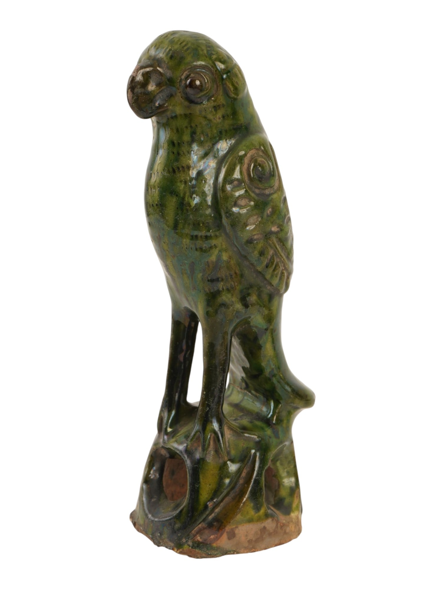 CHINESE GREEN GLAZED CARVED POTTERY PARROT FIGURINE: A Chinese pottery figurine depicting a parrot perched atop a pierced rockwork base, executed in molded earthenware and finished with a deep green glaze. The avian subject is rendered with stylized fea