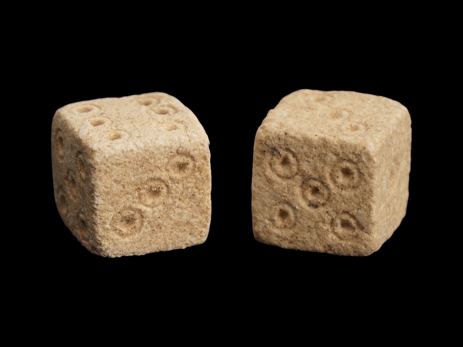 PAIR OF ANCIENT ROMAN STONE DICE 100-300 AD: A pair of ancient Roman hand carved stone dice, ca. 100 to 300 AD. Crafted with precision and care, these artifacts offer a tangible connection to the everyday life and leisure activities of the past.