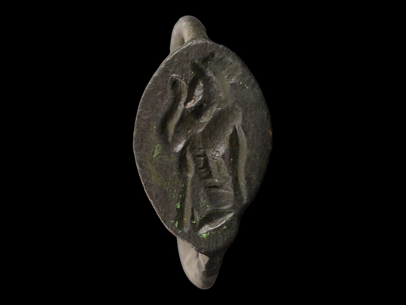 ANCIENT GRECO ROMAN BRONZE RING 400 TO 200 BC: An ancient Greco Roman bronze ring. Circa 400 to 200 BC. The ring features a rounded bezel centered on a gently elongated band, adorned with an engraved design representing a standing figure of a Deit
