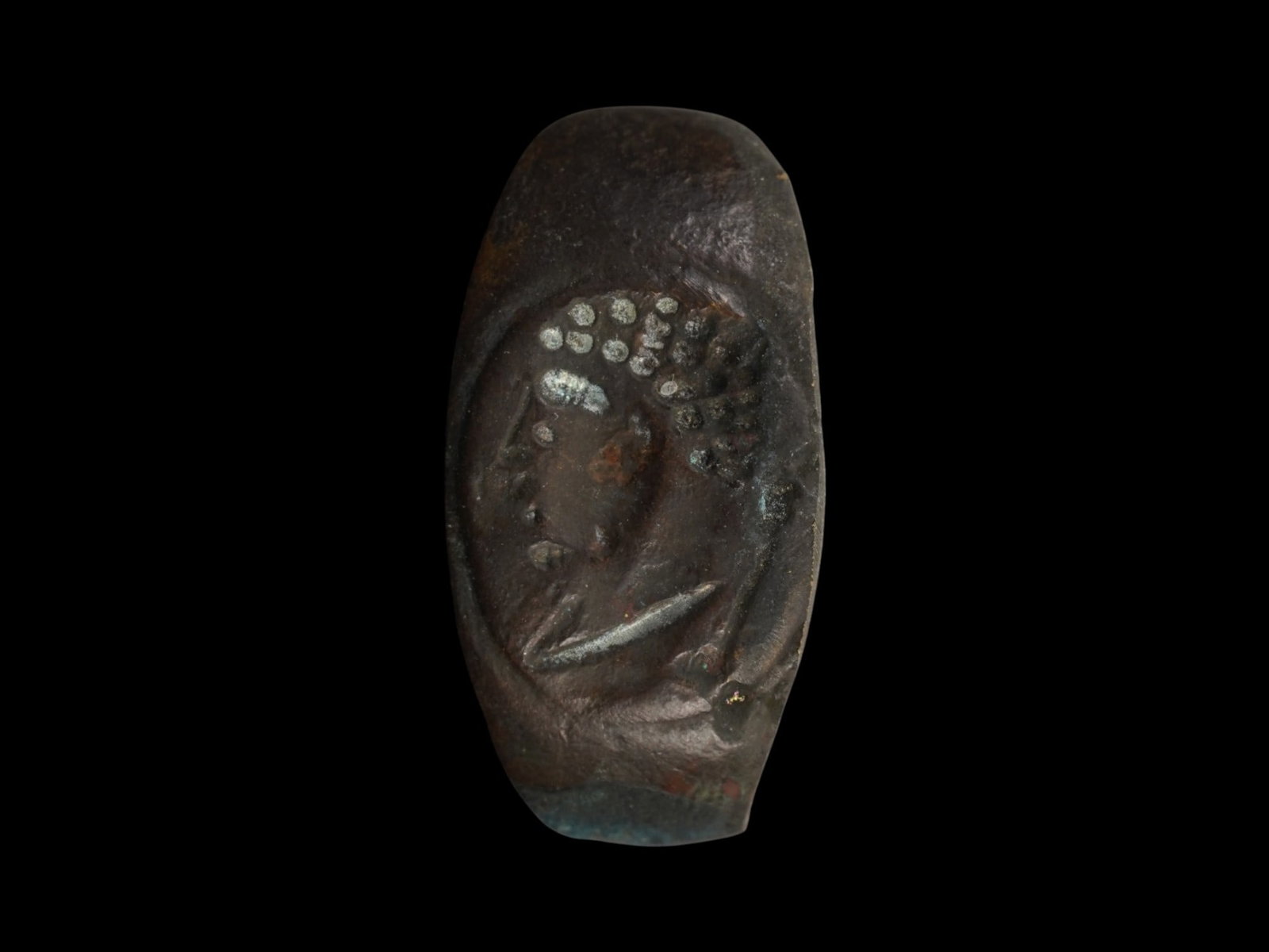 ANCIENT ROMAN BRONZE RING WITH HEAD OF DEITY HERCULES: An ancient Roman bronze ring, dating from approximately 100 BC to 200 AD, featuring a bezel cast with the head of a classical deity, possibly Hercules. The ring displays the robust form characteristic