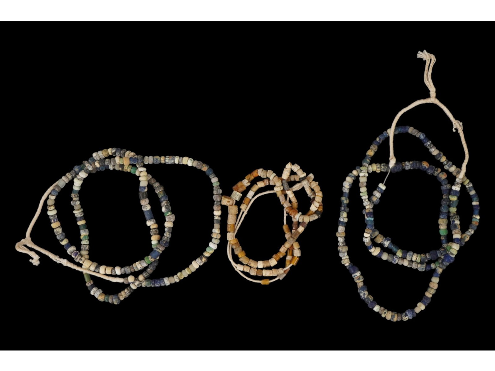 THREE ANCIENT ROMAN MULTICOLOR GLASS BEAD NECKLACES: A group of three ancient Roman multicolor glass bead necklaces, dating to approximately 100 to 300 AD. The necklaces are composed of varied glass beads showcasing the vibrant colors and craftsmanship 