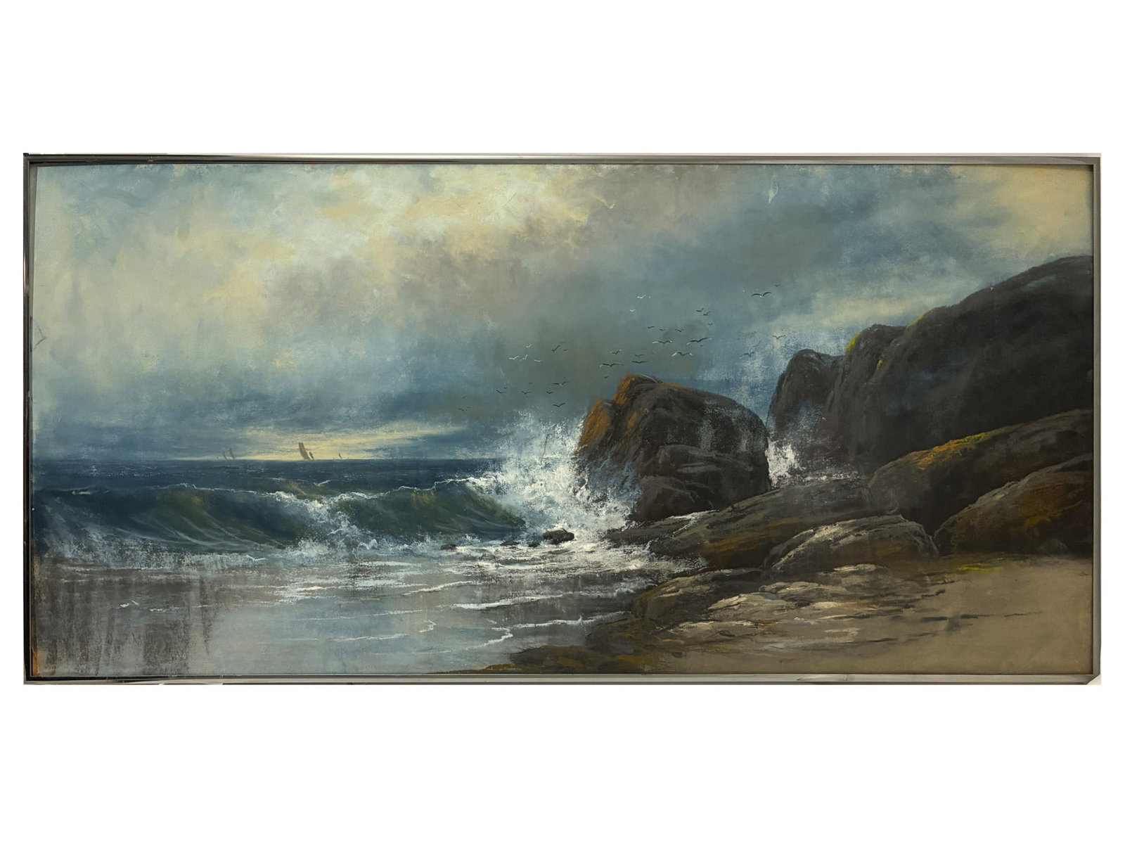 AMERICAN COASTAL SEASCAPE MARINE PASTEL PAINTING 20TH C: This panoramic coastal seascape is rendered in soft pastel on paper, depicting crashing ocean waves against dark, lichen-covered rock formations along a sandy shore. A flock of seagulls flies above th