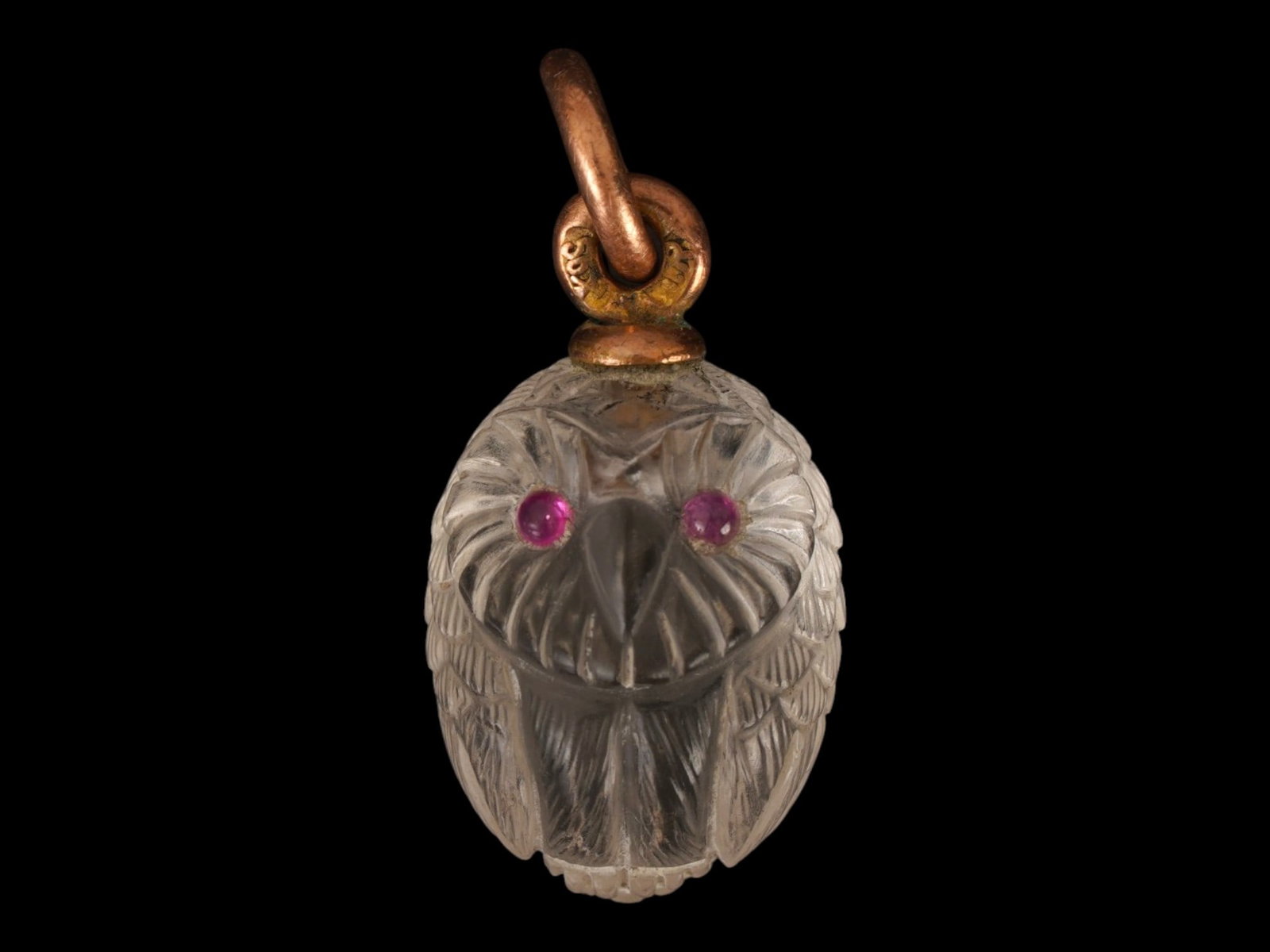 RUSSIAN GOLD ROCK CRYSTAL RUBY OWL EASTER EGG PENDANT: A Russian carved rock crystal Easter Egg pendant. Designed as an owl with ruby cabochon eyes. Hallmark of 56 gold standard and makers mark are on the fitting ring. Total Weight: 2.73 g. Russian