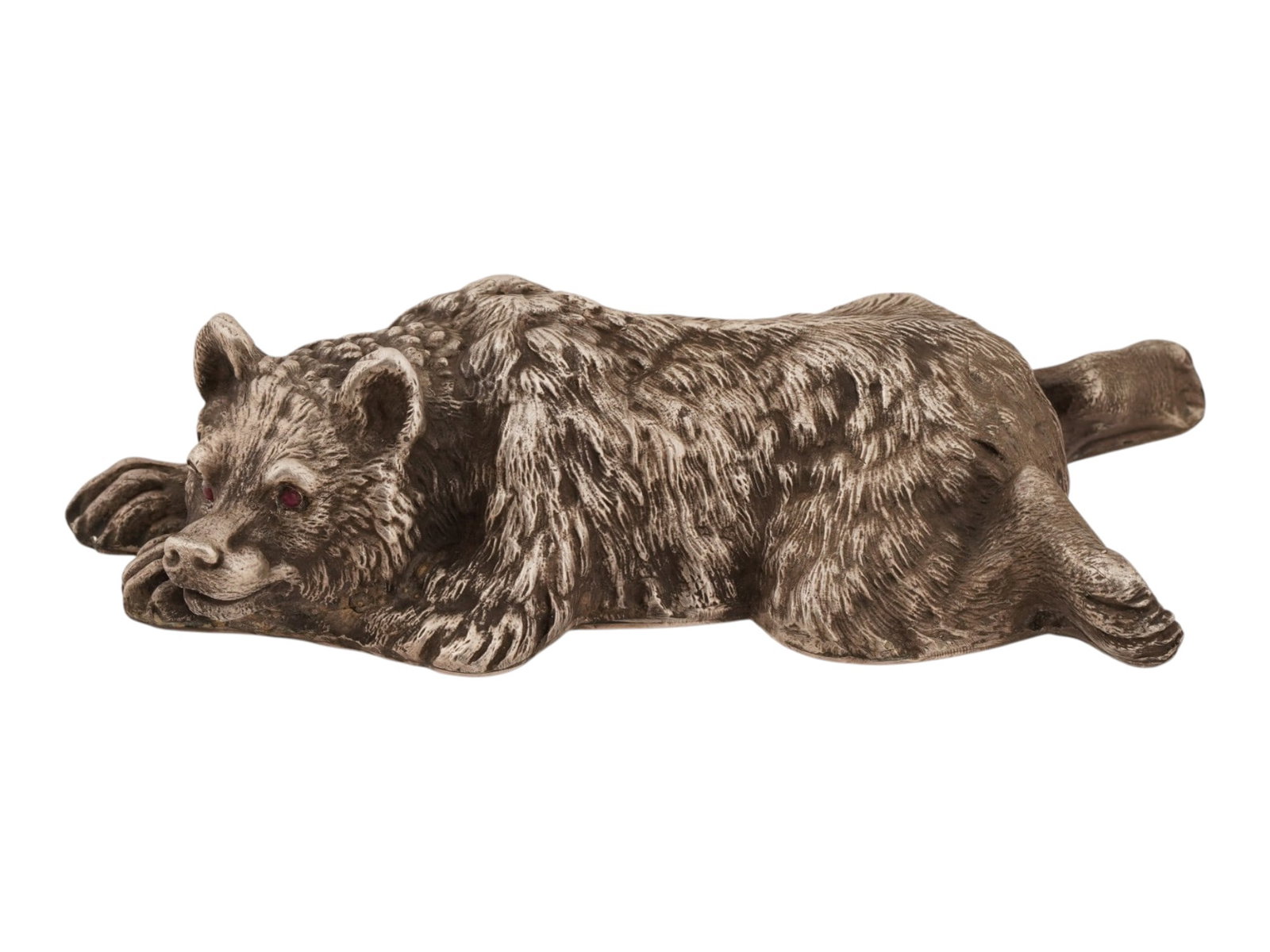 RUSSIAN SILVER BEAR FIGURINE WITH RUBY STONE EYES: A Russian naturally hand carved 84 Silver figurine. The figurine is made in the shape of a lying bear, engraved with detailed patterns, and encrusted with Ruby stone eyes. Marked with a Russian