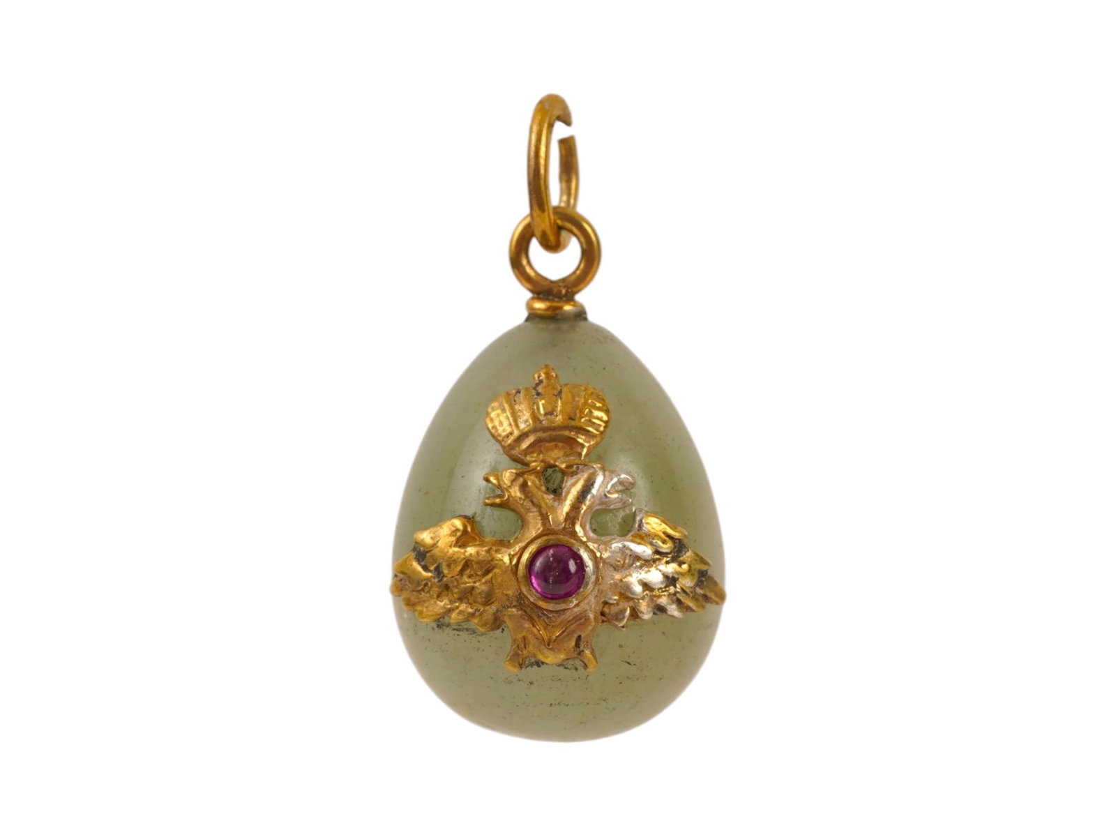 RUSSIAN SILVER JADE IMPERIAL EAGLE EASTER EGG PENDANT: A Russian carved jade Easter Egg pendant with gilt silver fittings. Overlay Imperial eagle set with a ruby cabochon on the obverse. Hallmark of 88 silver standard and makers mark are on the fitting ri