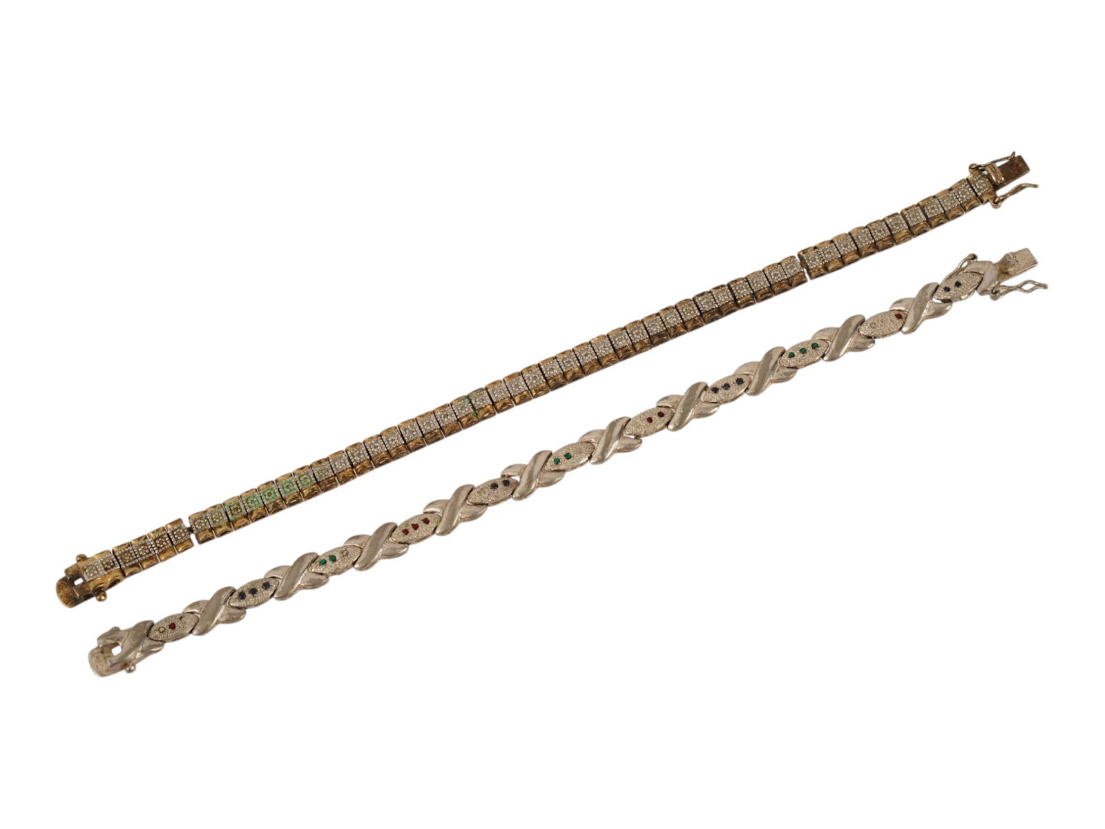 PAIR OF STERLING SILVER LINK BRACELETS: A pair of vintage sterling silver link bracelets. First. Gilded bracelet with rectangular links and relief flower or circle motif. Second. Bracelet composed of jeweled oval and X motives. Both are