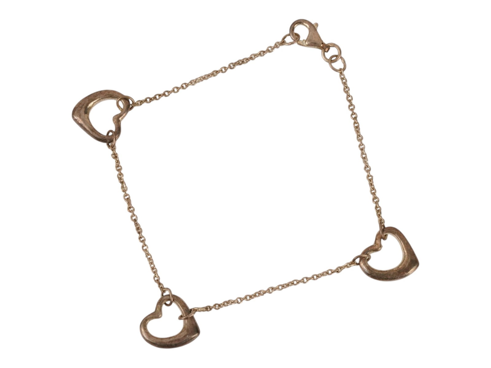 VINTAGE STERLING SILVER OPEN HEART STATION BRACELET: A vintage sterling silver multi-open-heart station bracelet in the style popularized by Elsa Peretti for Tiffany & Co. The bracelet features three smooth, asymmetrical open heart stations linked by de