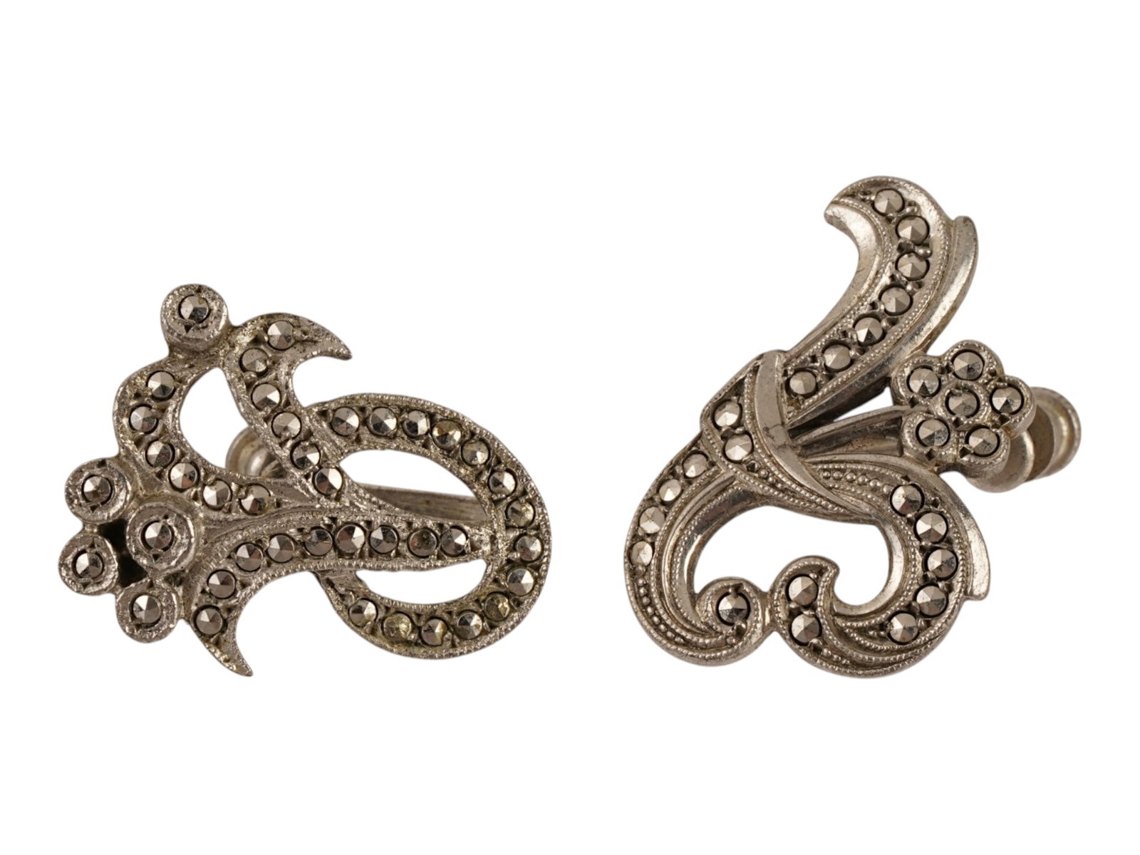 PAIR OF MARCASITE STERLING SILVER SCROLL EARRINGS: A pair of earrings crafted from sterling silver, featuring an intricate scrolling foliate design. Each earring is pavE set with numerous faceted marcasite stones that provide a subtle metallic luster 