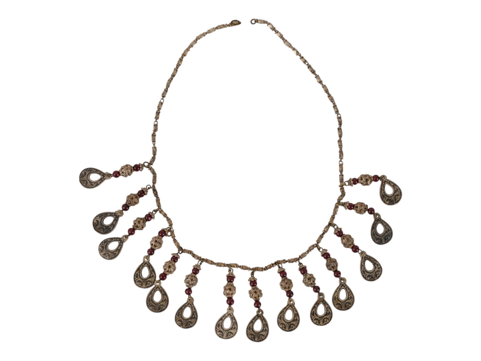 ANTIQUE ETHNIC SILVER MULTI DROP FRINGE NECKLACE: An antique ethnic silver multi-drop fringe necklace in the Persian style. The graduated design features thirteen engraved teardrop panels decorated with floral scrolls and arabesque motifs, accented b
