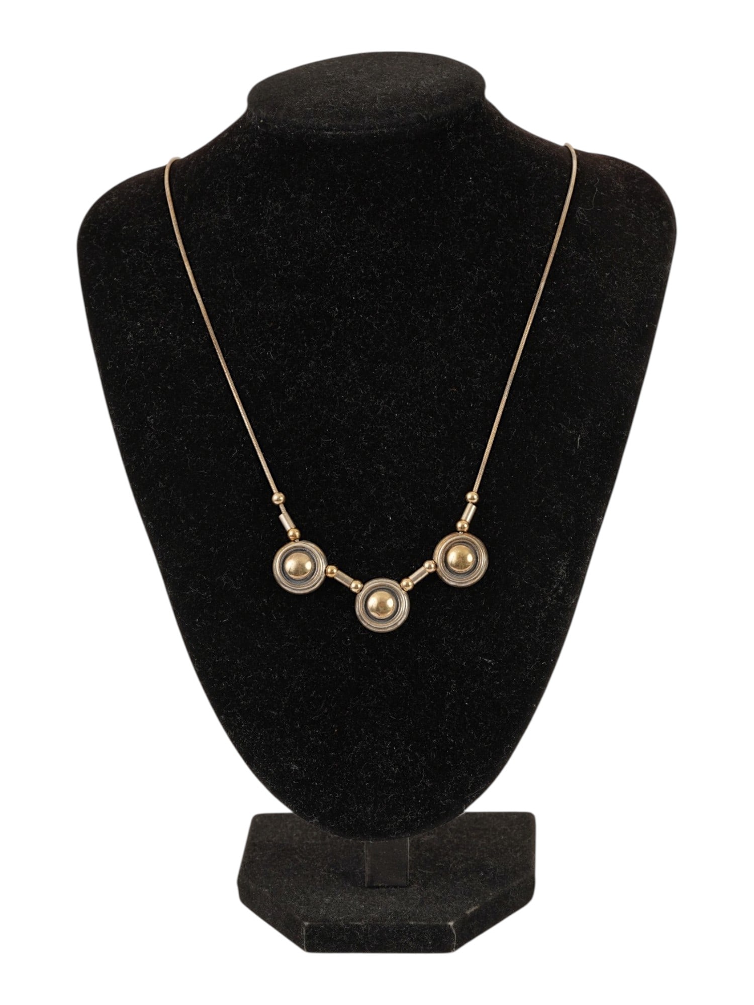 VINTAGE 14K GOLD STERLING SILVER THREE STATION NECKLACE: A vintage two-tone 14K gold and sterling silver three-station collar necklace, designed in a sleek mid-century modernist style. The necklace features three geometric circular stations with domed 14K y
