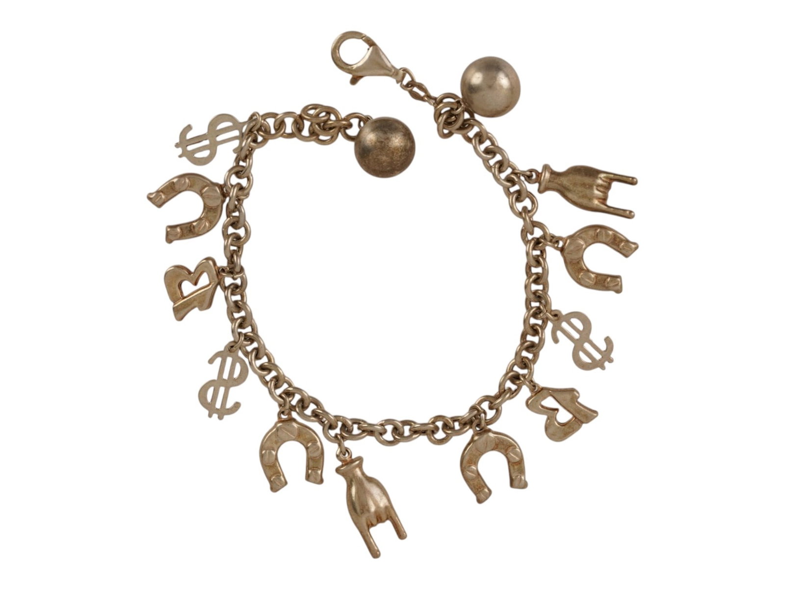 VINTAGE STERLING SILVER MULTI CHARM TALISMAN BRACELET: A vintage sterling silver multi-charm talisman bracelet, decorated with horseshoes, Mano Cornuta hands, dollar signs, letter charms, and spherical silver orbs. The charms are suspended from a double-l