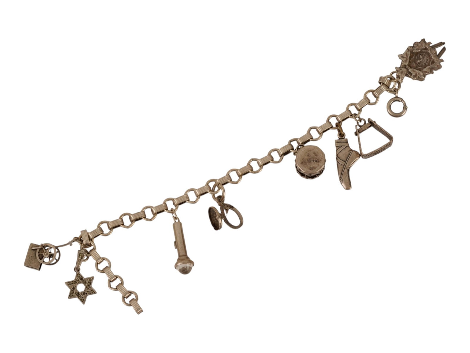 MEXICAN STERLING SILVER MULTI CHARM LINK BRACELET: A sterling silver link bracelet featuring a spring ring closure and is adorned with seven distinct charms of various themes. Several components are stamped with Sterling Silver and Mexica hallmarks. T