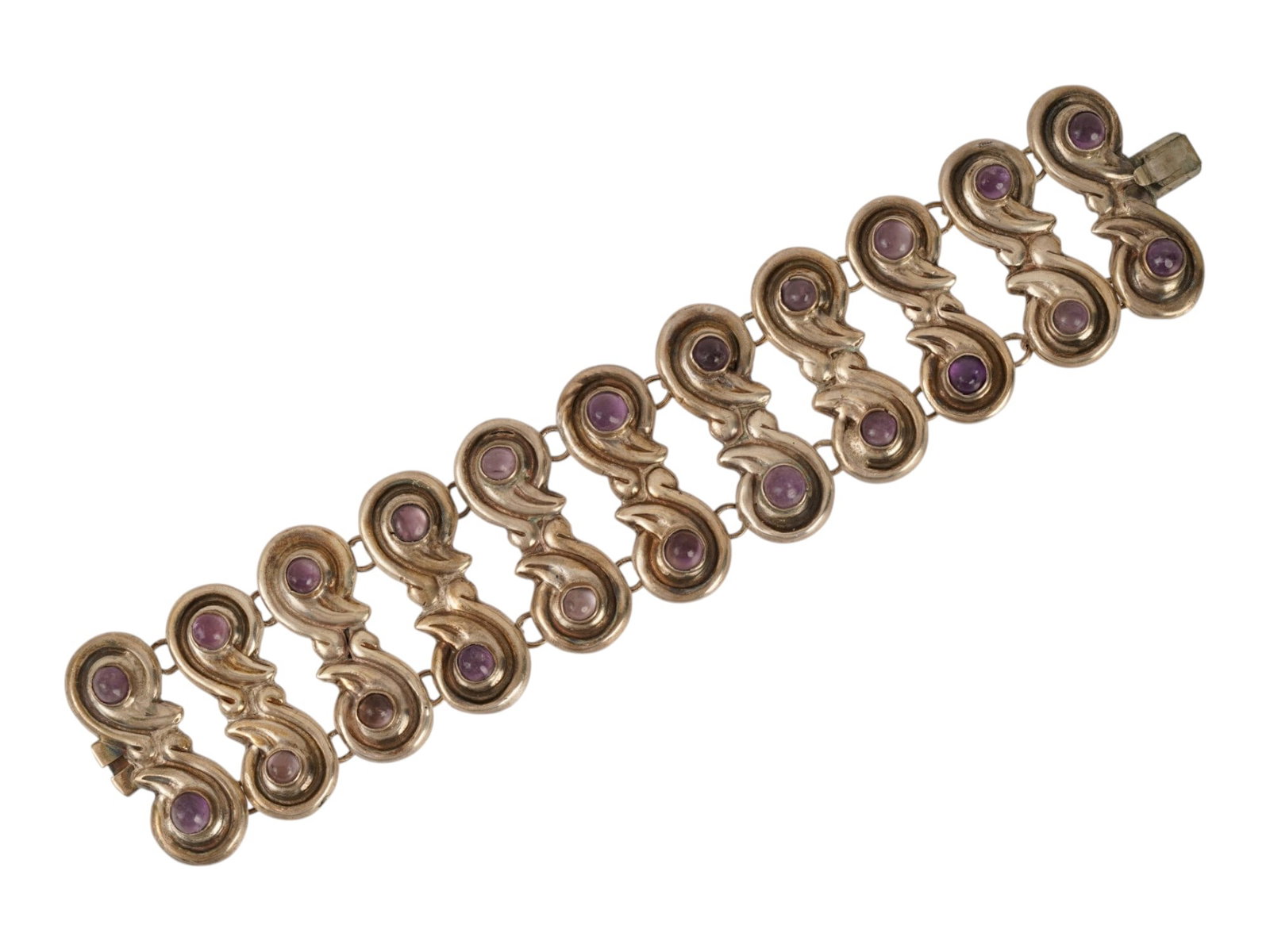 VINTAGE MEXICAN STERLING SILVER AND AMETHYST BRACELET: A vintage Mexican Modernist sterling silver and amethyst cabochon link panel bracelet. The bracelet features ten articulated S-shaped scroll panels, each set with purple amethyst cabochons, and an int