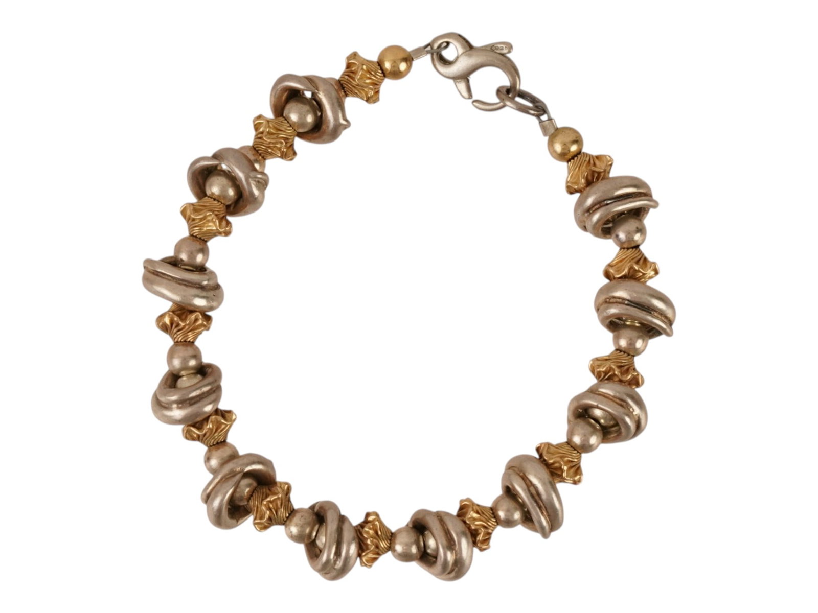MODERNIST SWIRLING DESIGN STERLING SILVER BRACELET: A modernist sterling silver bracelet featuring a sequential arrangement of textured silver focal beads interspersed with smaller, gold tone bicone accents. The design incorporates tactile, organic for