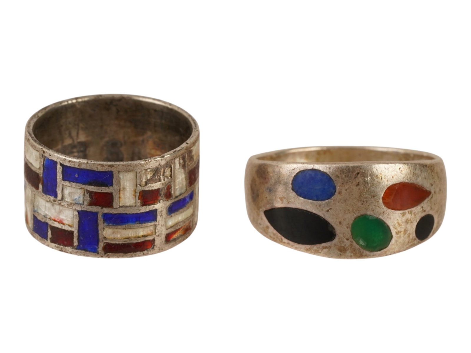 PAIR OF STERLING SILVER ENAMEL BAND RINGS: A pair of vintage sterling silver band rings. Each is garnished with polychrome enamel geometric pattern of various design. The wider piece is marked Siam Sterling 925. The dome ring is marked 925. Vi