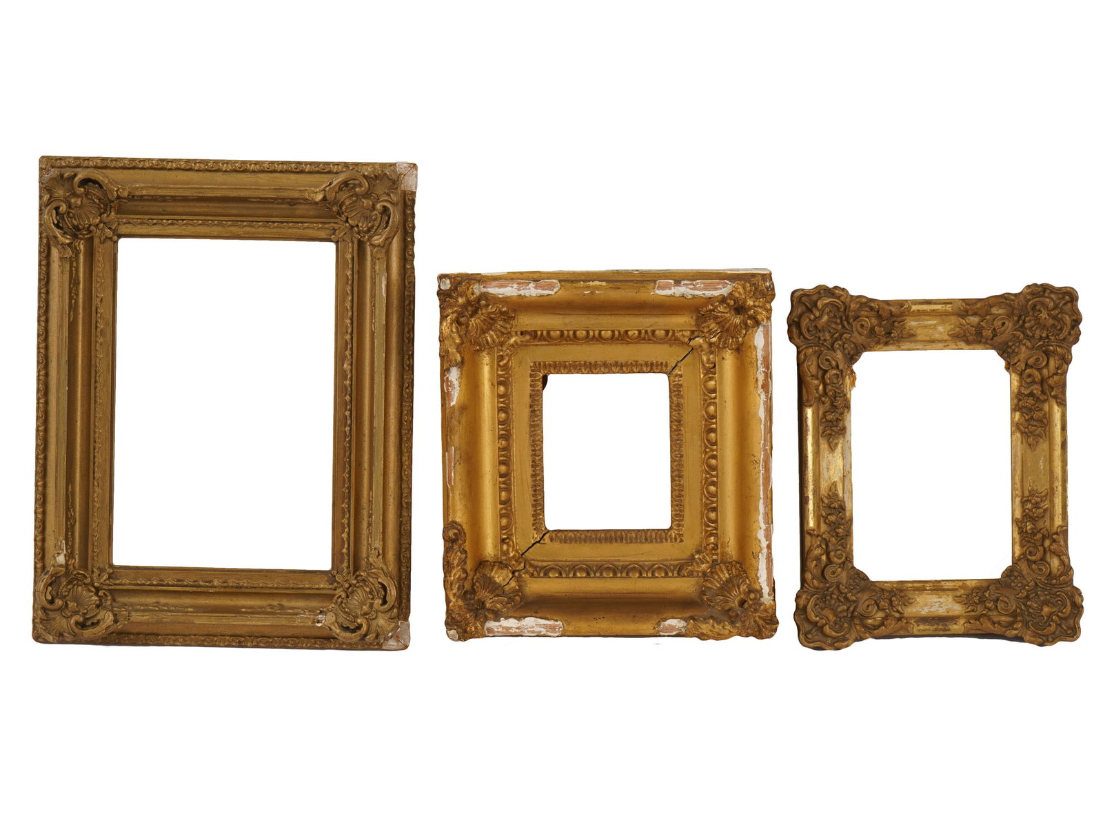 COLLECTION OF VINTAGE GILTWOOD DECORATIVE FRAMES: A collection of three frames of varying sizes and styles, each featuring a gilded finish over wood. The largest frame displays a classic rectangular profile with foliate corner accents, while the midd