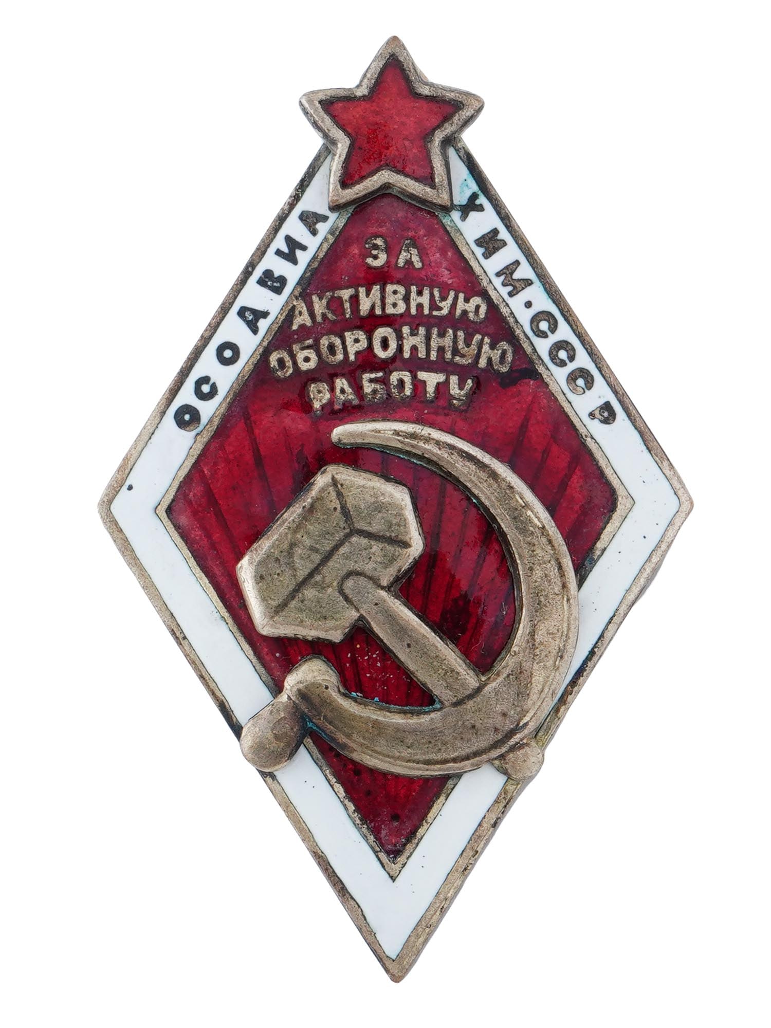 RUSSIAN SOVIET F ACTIVE DEFENSE WORK BRONZE BADGE: A Russian Soviet enameled bronze badge For Active Defense Work. The badge is a red rhombus with a white edge. In the middle is a relief image of the hammer and sickle of the Soviet Union and the inscr