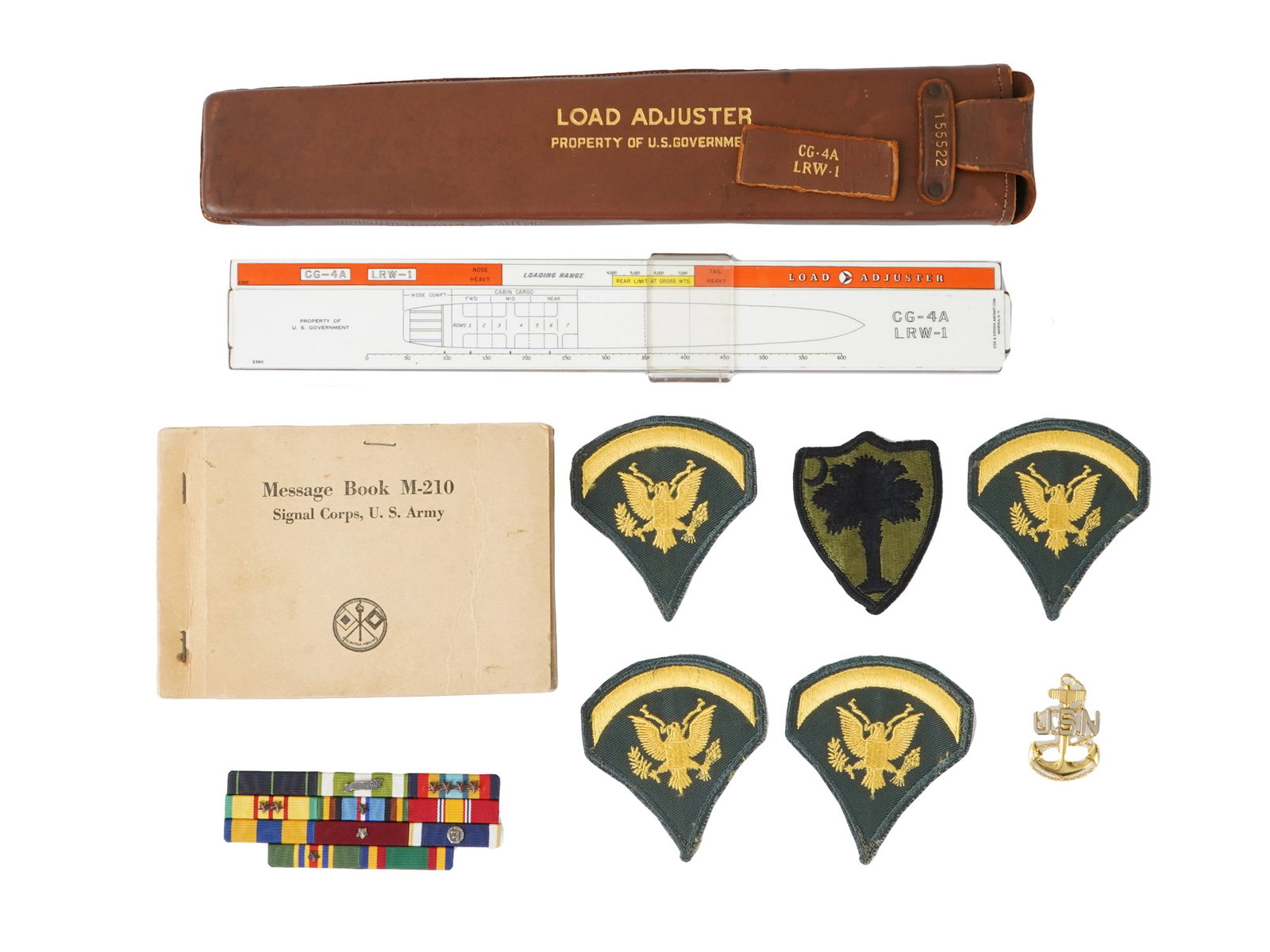 WWII U.S. MILITARY LIBERATOR LOAD ADJUSTER MESSAGE BOOK: A WWII-era U.S. military aviation lot including a B-24 and PB4Y Liberator Load Adjuster with its original case, a Message Book M-210, and a selection of vintage military patches. The load adjuster, us