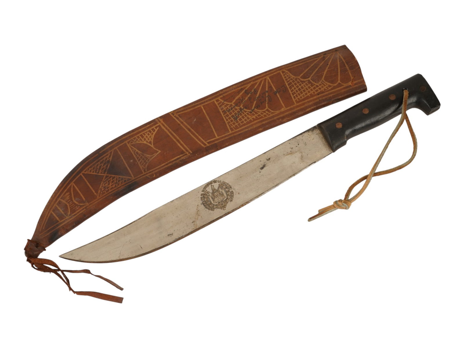 VINTAGE SOUTH AMERICAN MACHETE W TOOLED LEATHER SHEATH: A vintage South American machete with a steel blade bearing a regional or manufacturer's stamp. The knife features a black handle with a hooked pommel and leather wrist lanyard. Accompanied by an