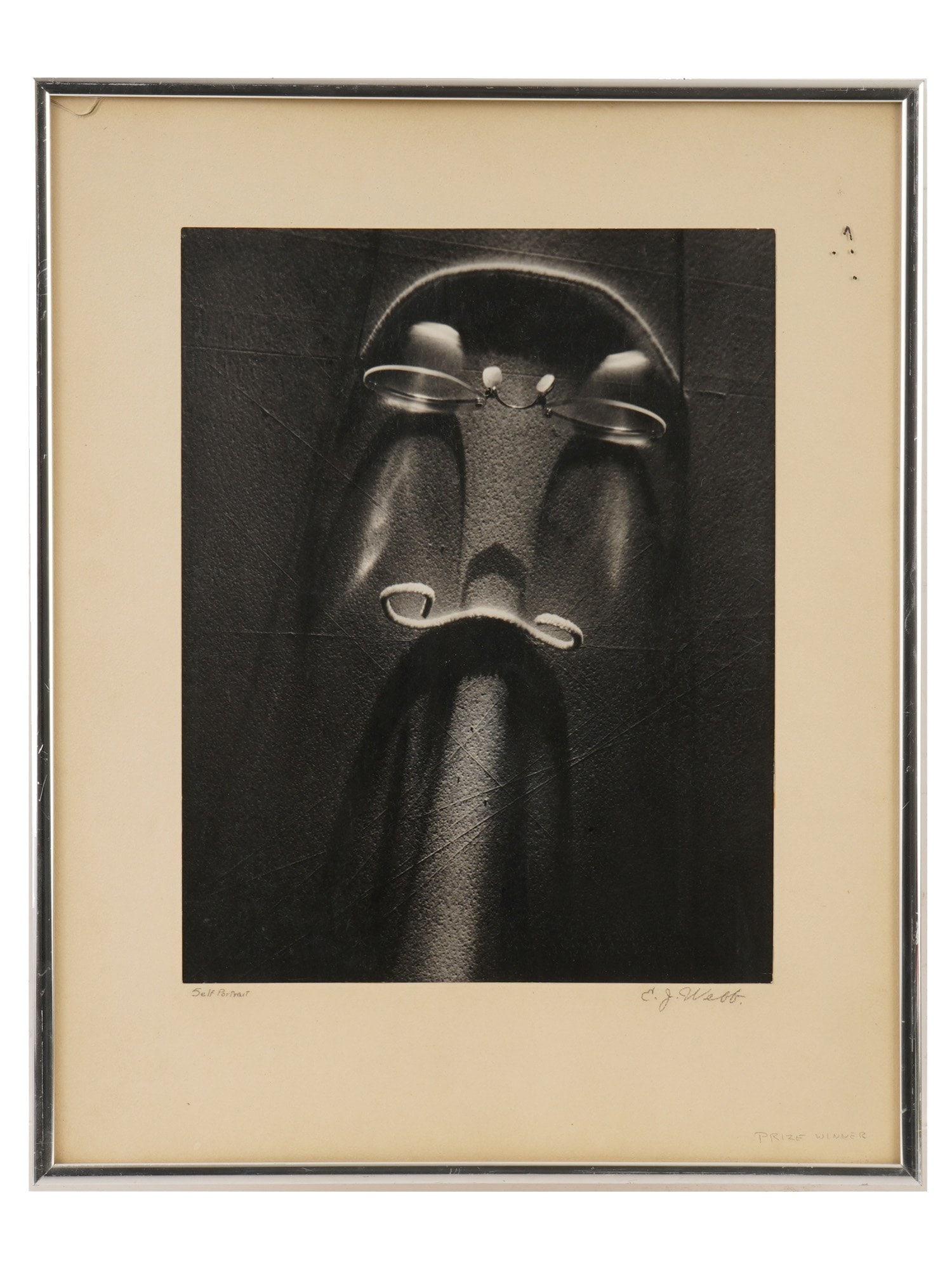 LIMITED EDITION FINE ART PHOTOGRAPH SIGNED E. J. WEBB: Fine art photograph on paper. The artwork depicts a pair of glasses and bent wire which resemble a face due to the light reflexion. Titled Self Portrait. Signed lower right, E.J. Webb. Marked Prize Wi