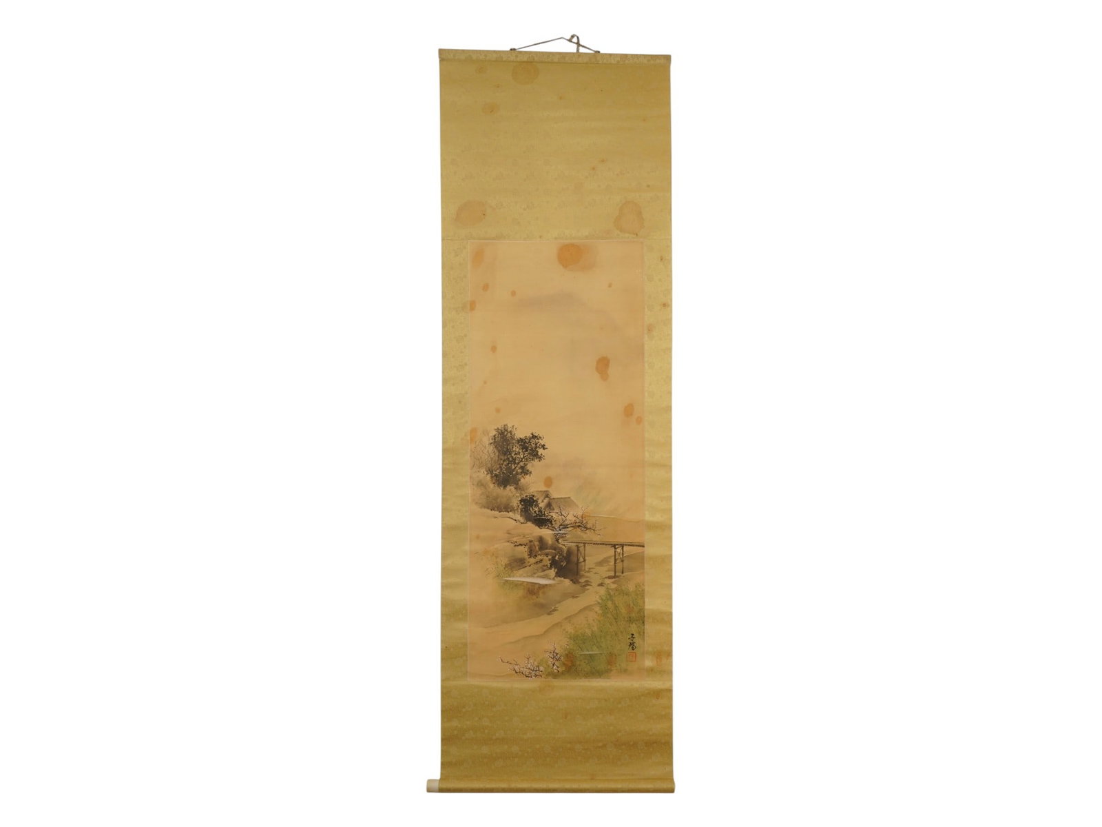 JAPANESE RIVER LANDSCAPE WATERCOLOR SCROLL PAINTING: A Japanese watercolor and ink painting on silk. The piece depicts a river landscape with cherry blossoms. Signature and artist's seal lower right. One color mount. Wooden bars with suspension. Collect