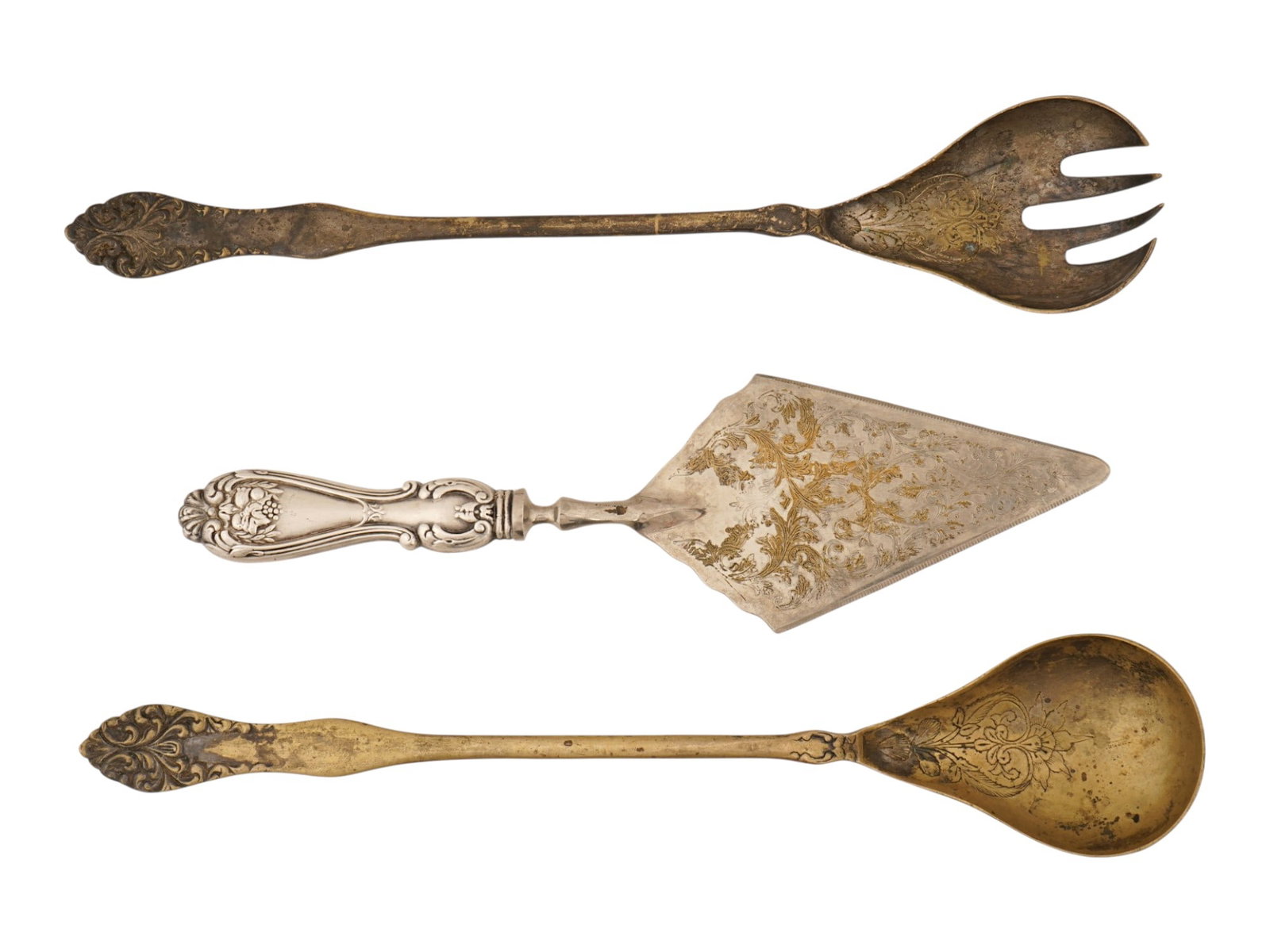 LOT OF SERVING WARES SALAD FORK SPOON CAKE SERVER: A collection of three vintage serving ware including a matched salad fork and spoon set alongside a decorative cake server. Each piece features elaborate scrollwork and foliate motifs on the handles. 