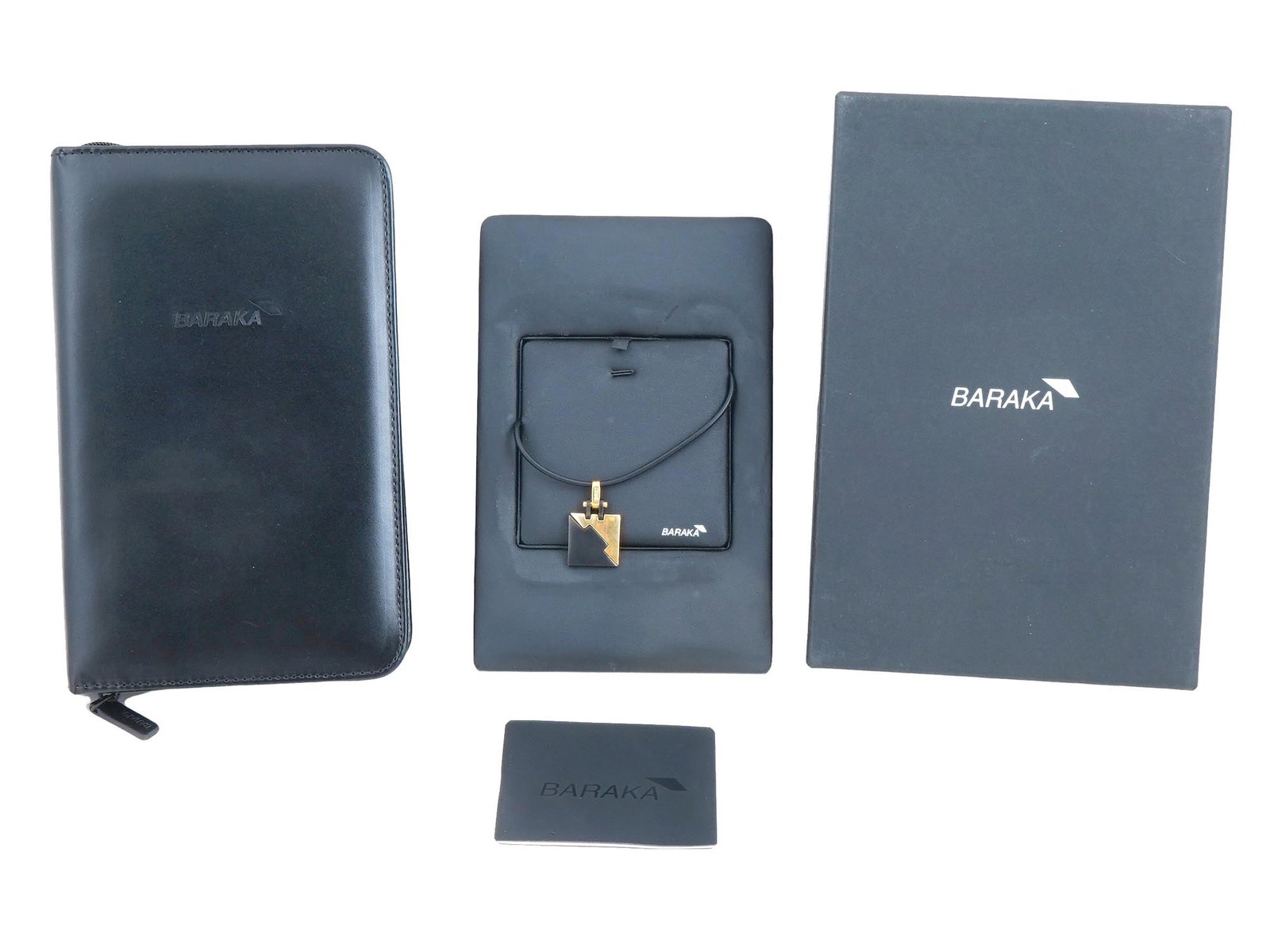 ITALIAN BARAKA 18K GOLD AND BLACK CERAMIC PENDANT: An Italian Baraka Mens 18k Gold and black ceramic pendant. The rectangular shaped pendant, marked, Baraka. Completed with a black cord. Marked with a brand logo mark, a Gold hallmark, and an Italy
