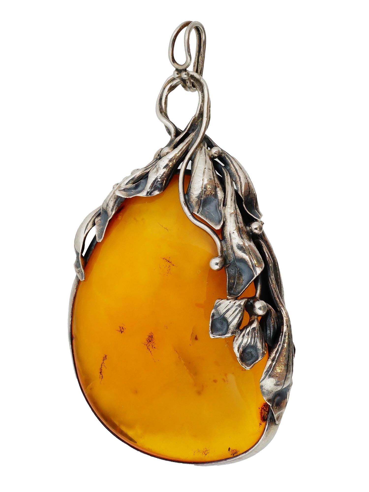 ANTIQUE NATURAL AMBER SILVER FOLIAGE FRAMED PENDANT: An antique natural amber gemstone set in a silver frame featuring intricate foliage motifs. The silver is stamped with the 875 purity mark and bears the manufacturer hallmarks. Complete with a