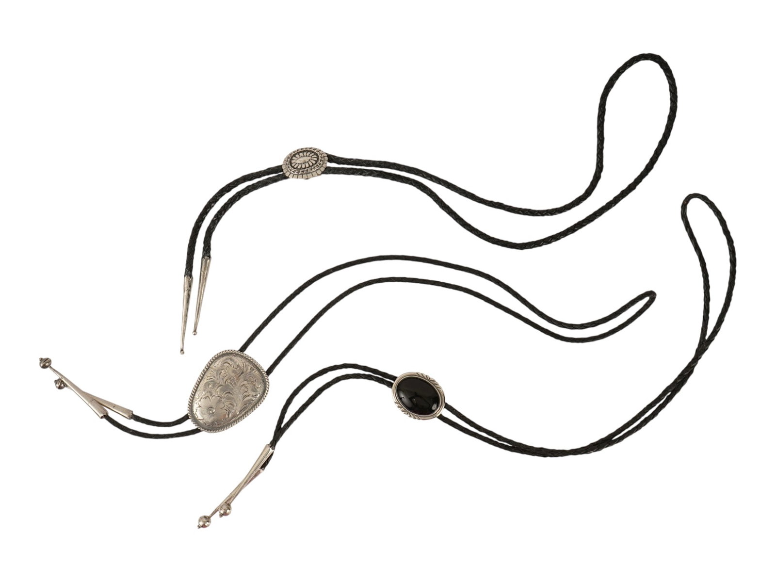 VINTAGE AMERICAN OLD PAWN STERLING SILVER BOLO TIES: A set of three vintage American Old Pawn sterling silver bolo ties. The set includes a stamped sunburst concho, a bright-cut engraved shield design, and an oval black onyx cabochon set within a rope-a