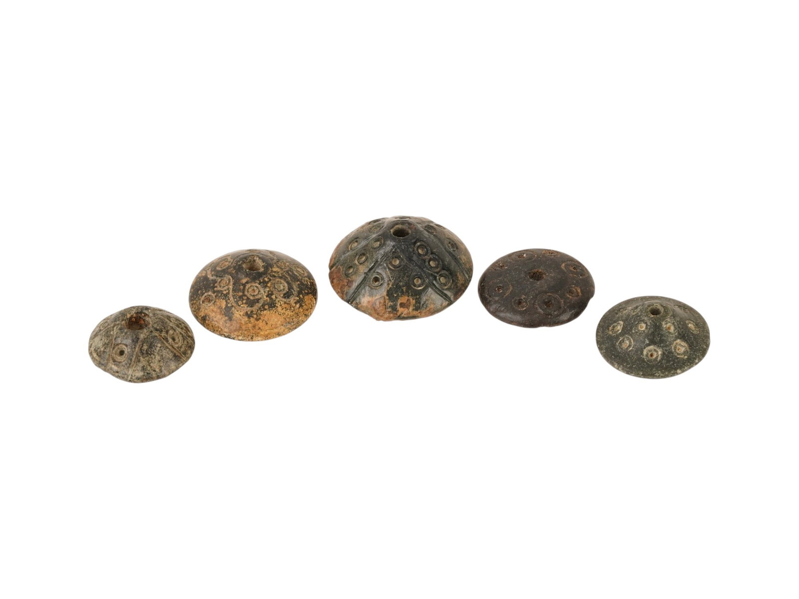 ANCIENT HOLY LAND STONE SPINDLE WHORLS 300 BC TO 100 AD: A lot of five ancient Roman carved Steatite stone spindle whorls, each intricately engraved with geometric motifs and circular patterns. Circa: 100 to 300 AD. Their detailed engravings highlight both 