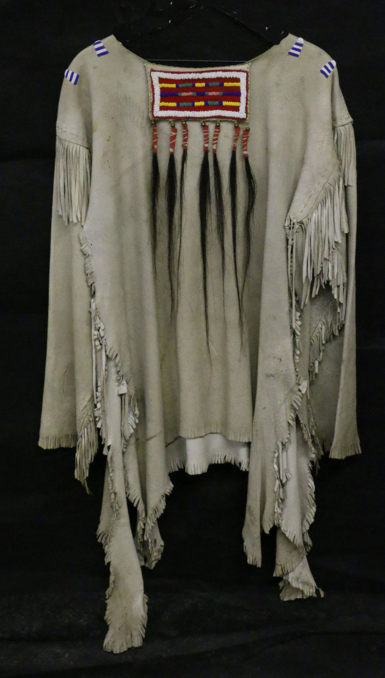 Plains Indian Leather Shirt - Beaded: Plains Indian Leather Shirt with Beaded decoration and 7 human hair drops, 45.5" long, sinew-sewn.
