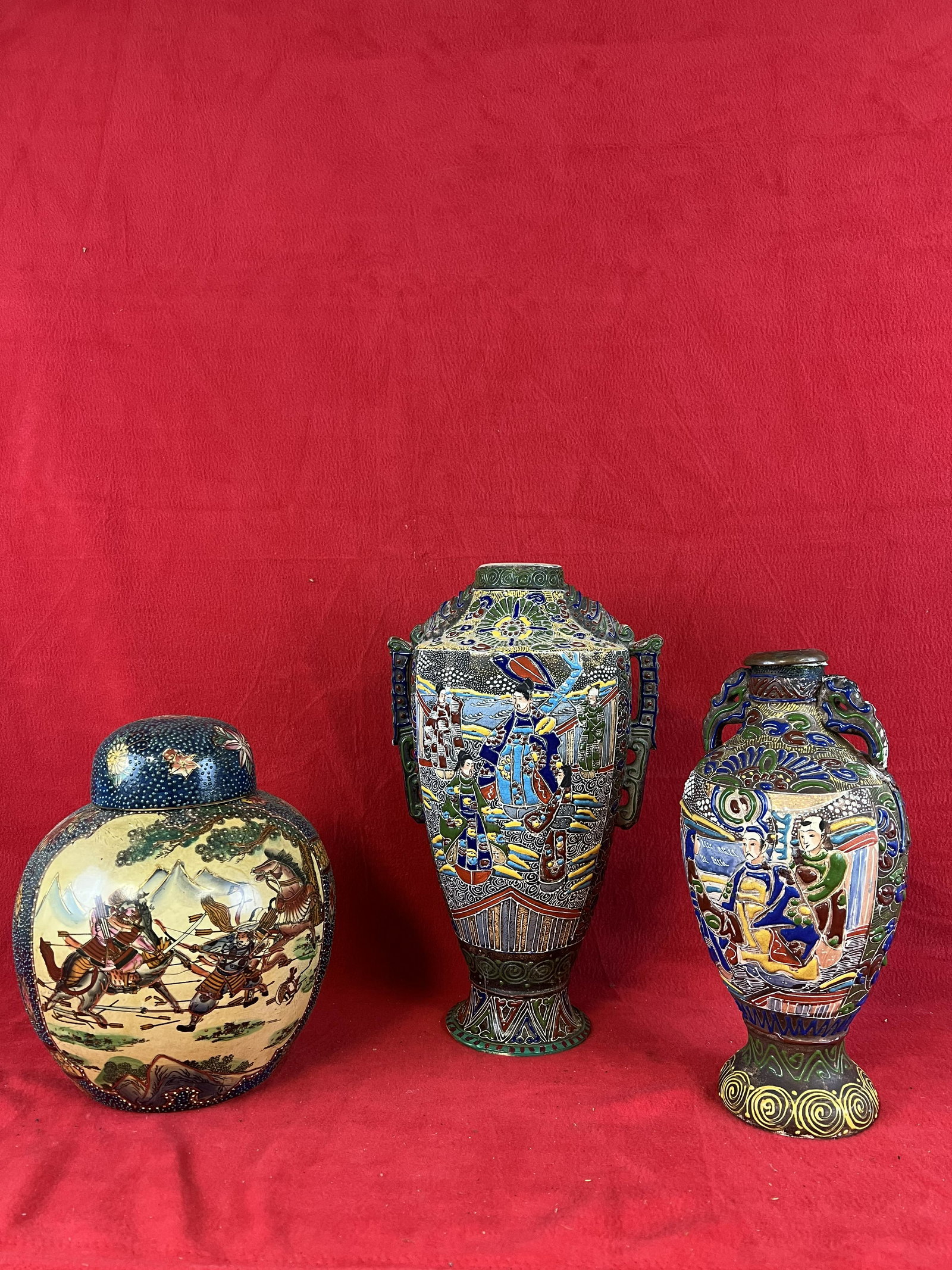 Lot of Three Japanese Satsuma Pottery Pieces: Lot of Three Japanese Satsuma Pottery Pieces which include two vases the tallest of which measures approximately 14 1/4" tall and a ginger jar with cover. The shorter of the two vases has a couple chi