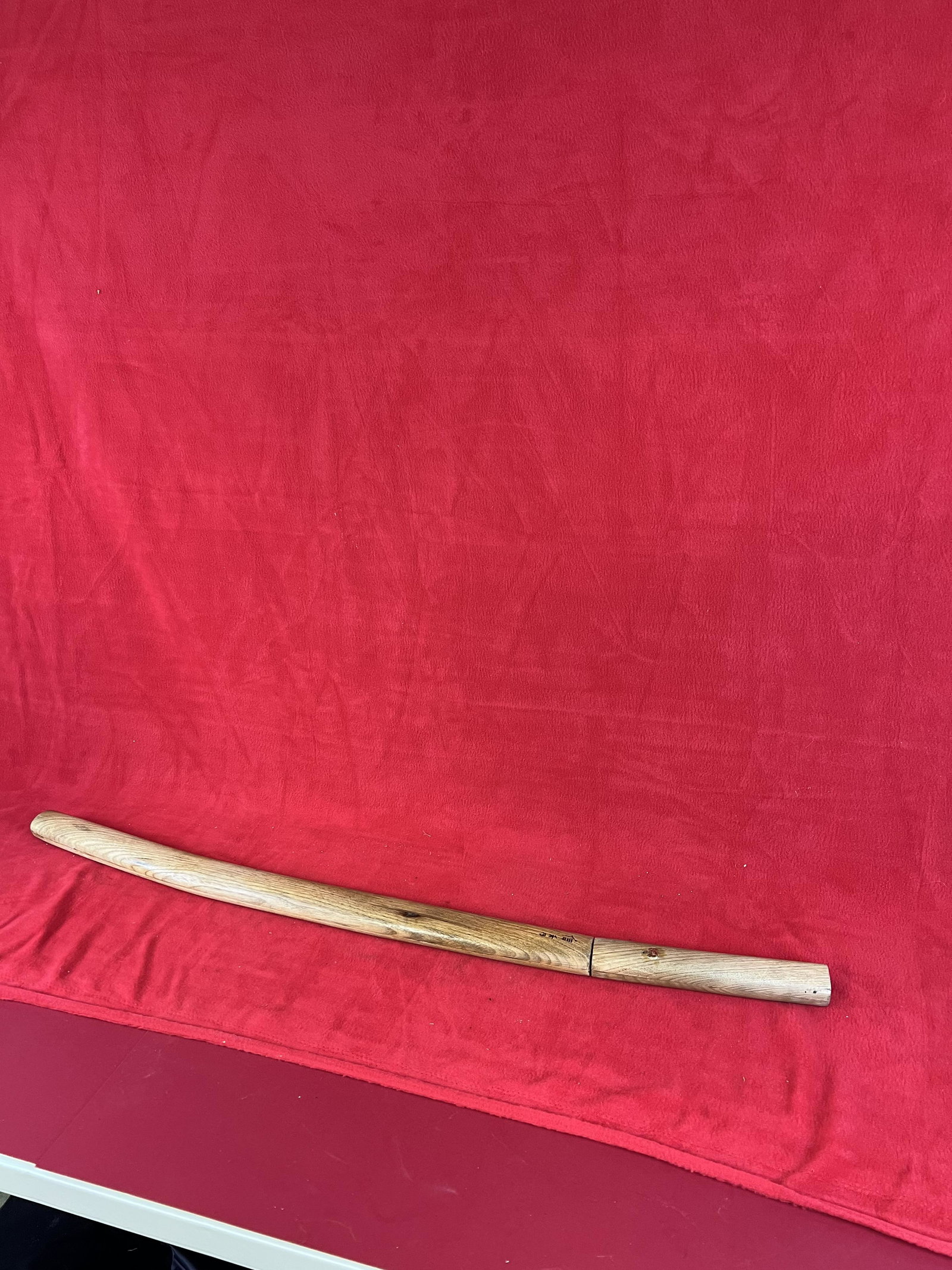 Japanese Samurai Sword: Japanese Samurai Sword with wooden handle and scabbard which is signed in Japanese characters. The blade measures approximately 29" long. Blade has some pitting and some rust spotting toward the tip.