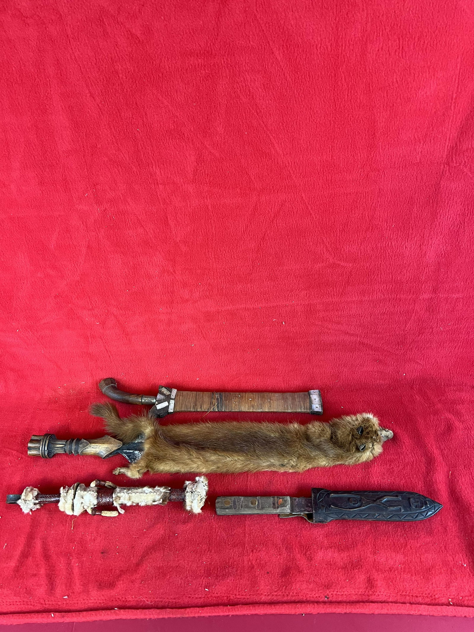Lot of four African? Daggers and Knives: Lot of four African? Daggers and Knives which include a non African made skinning knife in a carved wooden sheath which depicts a human; a interesting dagger housed in a leather and fur covered sheath