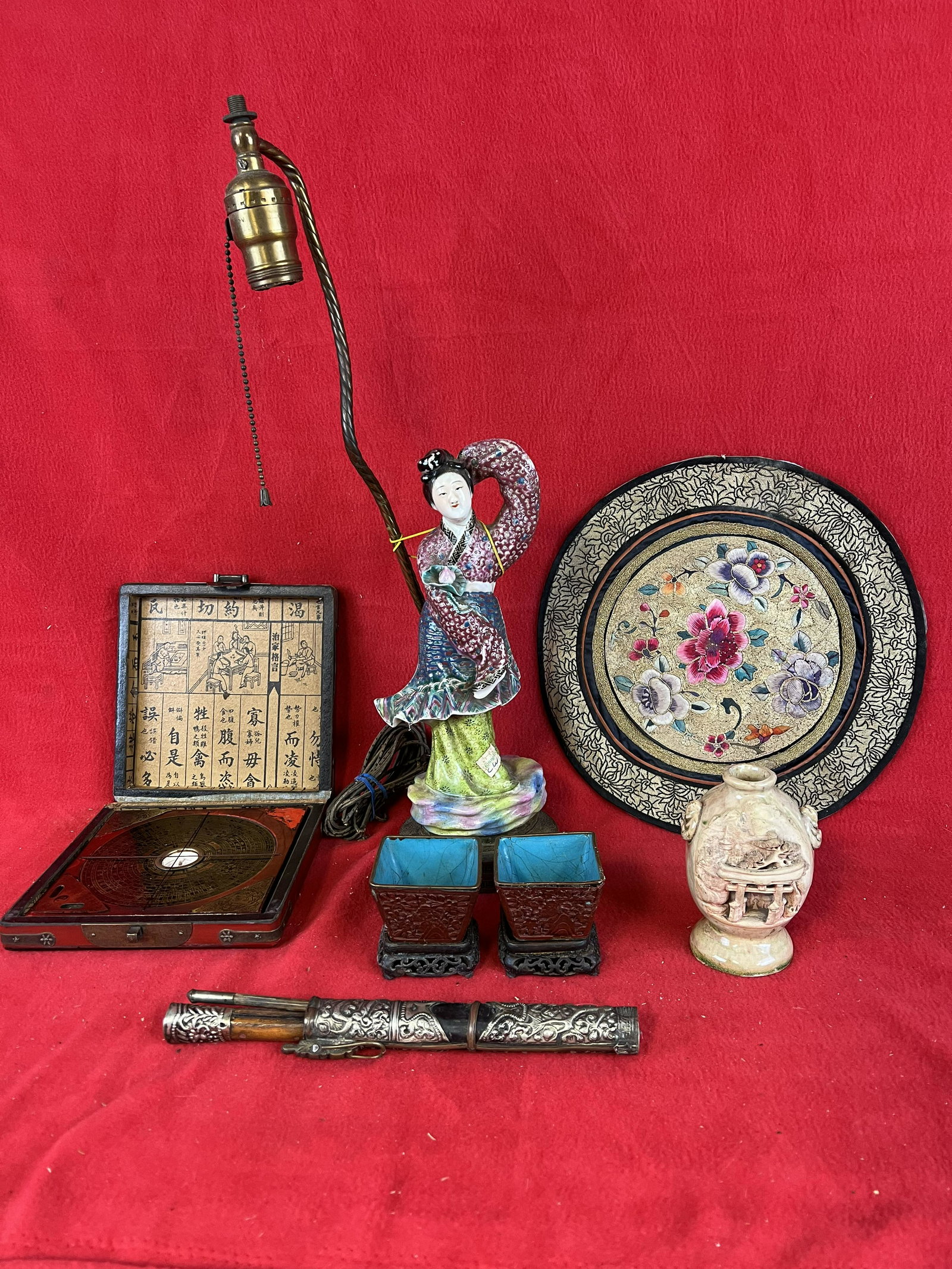 Lot of Vintage Asian Decorative Items: Lot of Vintage Asian Decorative Items to include a cased compass, a 11" diameter needlework, a 4 1/2" tall scenic carved pottery vase, a cased set of eating utensils, a pair of small cinnabar vases on