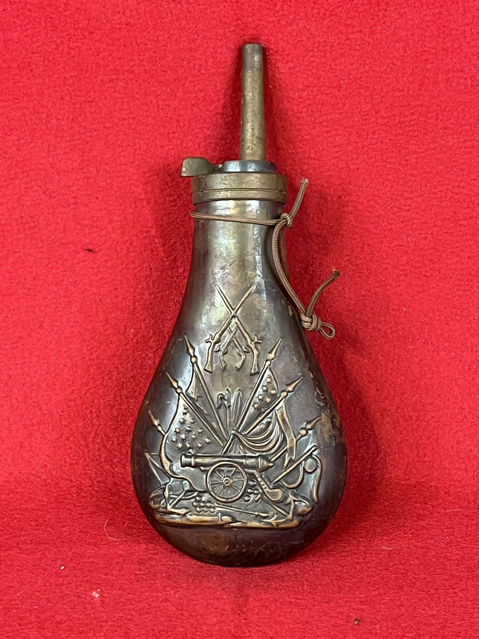 1960's Italian Brass Civil War Powder Flask: A circa 1960's Italian made replica stamped brass Civil War powder flask which measures approximately 8" tall and features a military motif with cannon, crossed rifles etc. Condition - fine as shown.