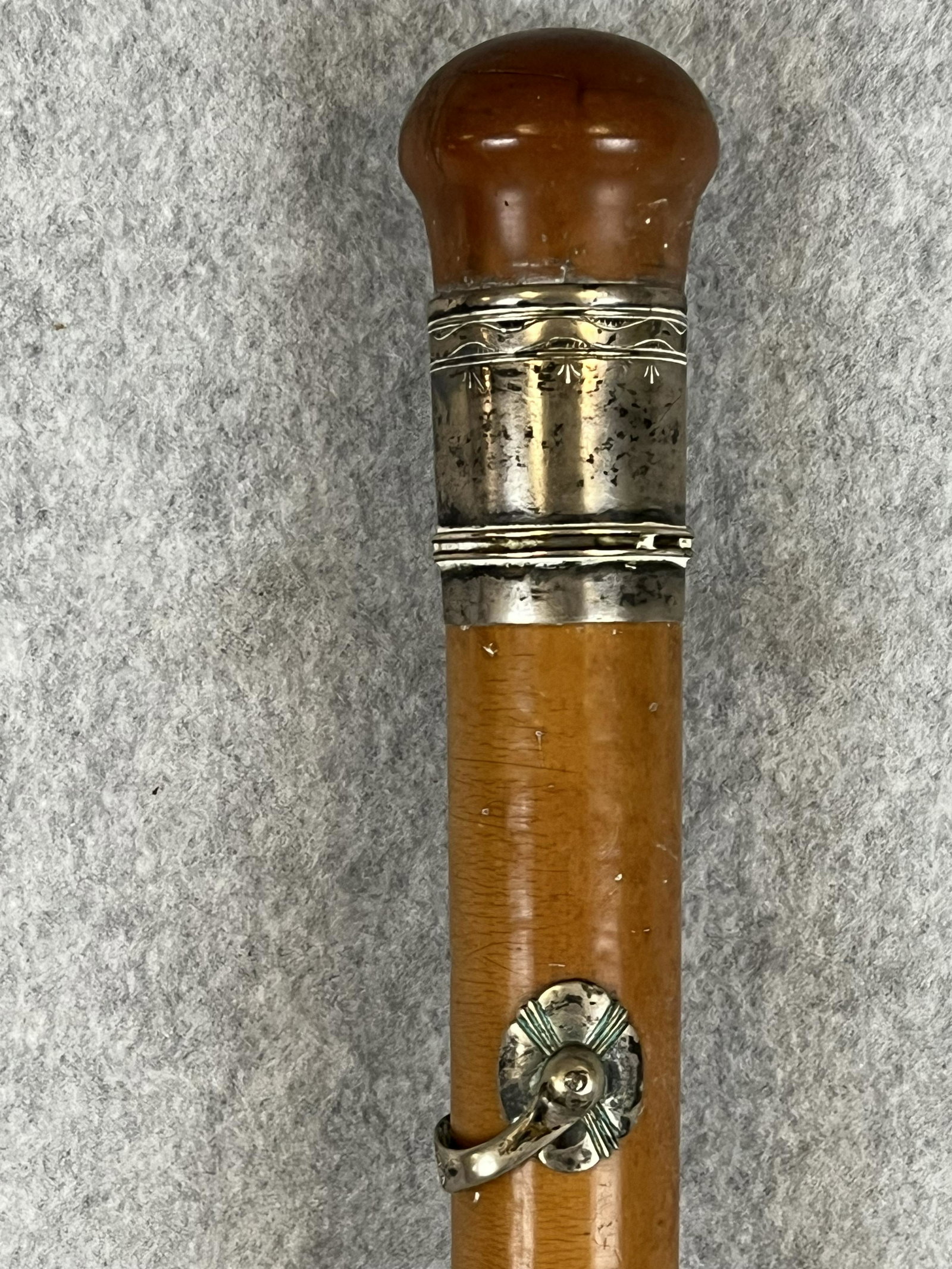 18th C Cane / Walking Stick: Antique late 18th or very early 19th century cane / walking stick with a malacca shaft and having a coin silver or sterling silver collar at top and a eyelet swivel both of which are decorated with ha