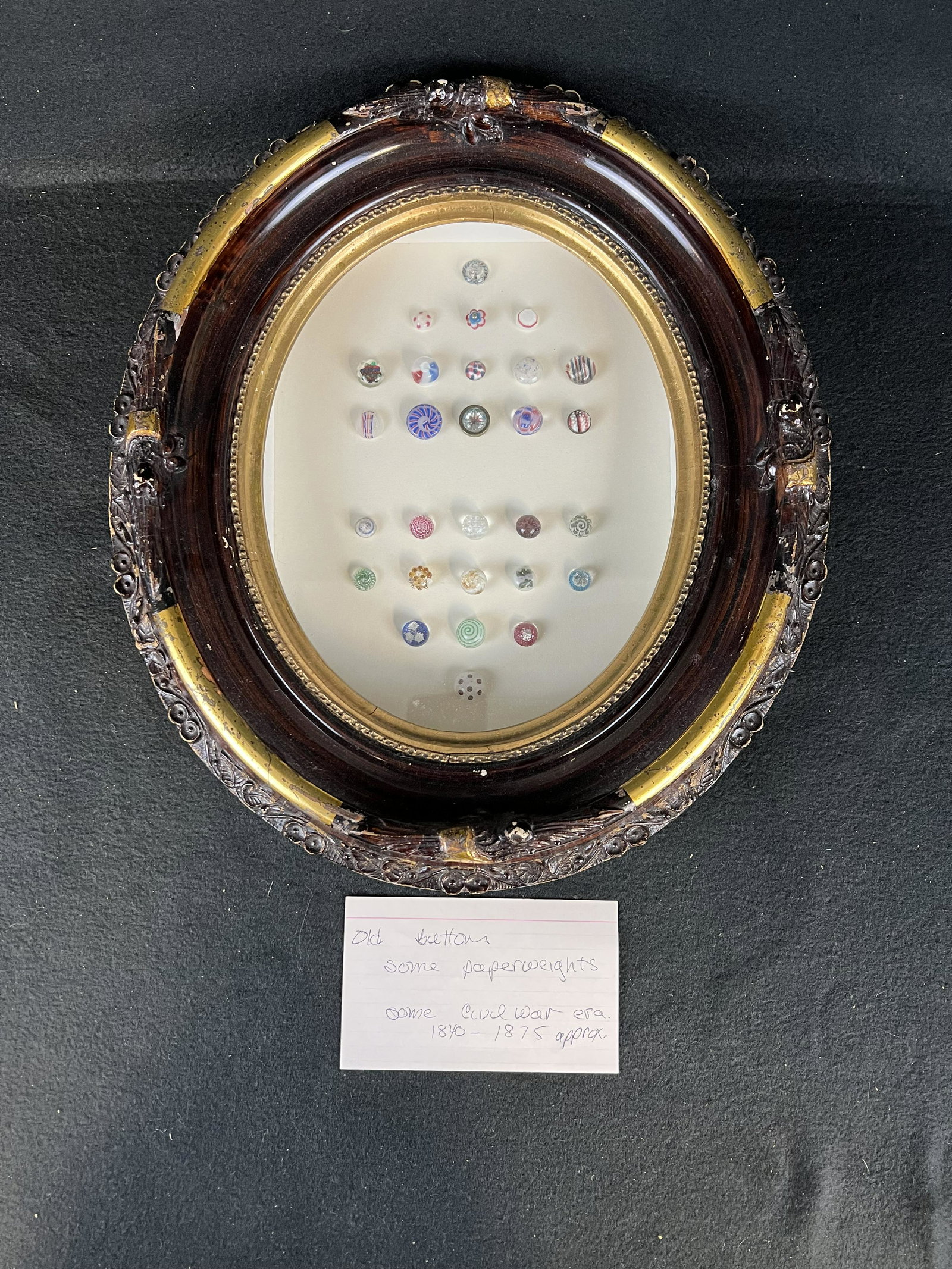 Framed Lot Of Civil War Era Buttons: A framed group of antique buttons to include some paperweights as well as some from the era of the Civil War all in a Civil War era gesso over wooden oval shadow box picture frame in nice condition
