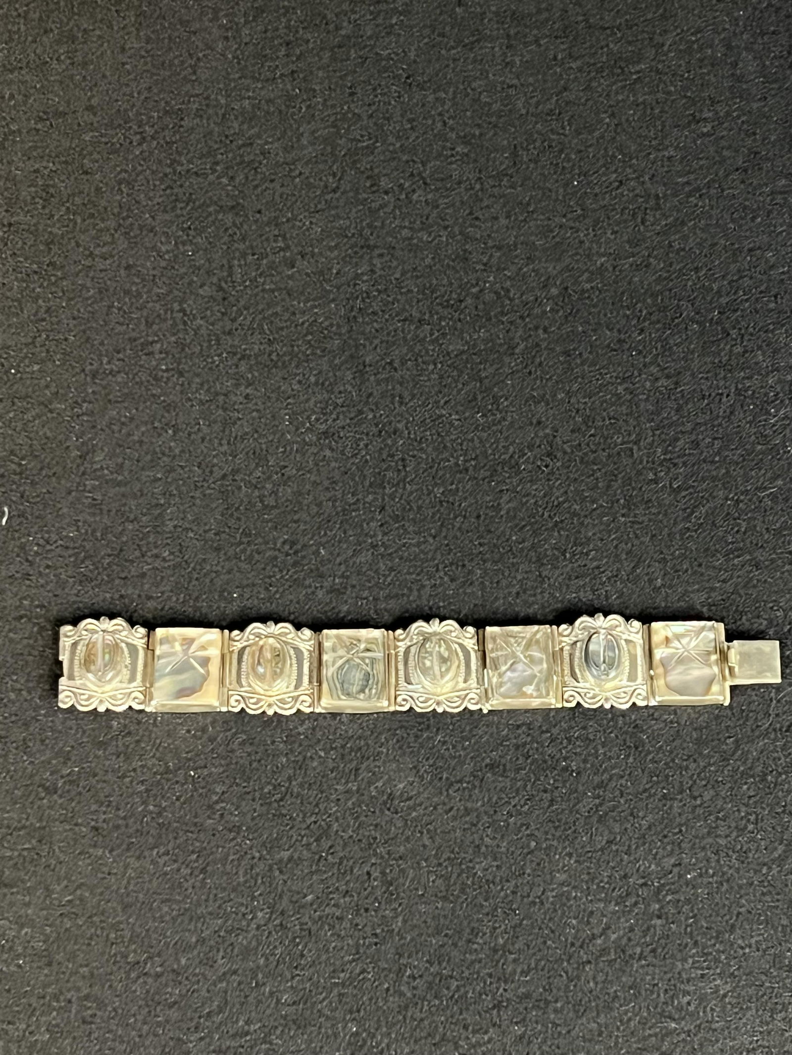 Taxco Sterling Silver And Abalone Shell Bracelet: Taxco sterling silver bracelet with carved abalone shell panels which has a weight of 56.1 grams. Condition - fine.