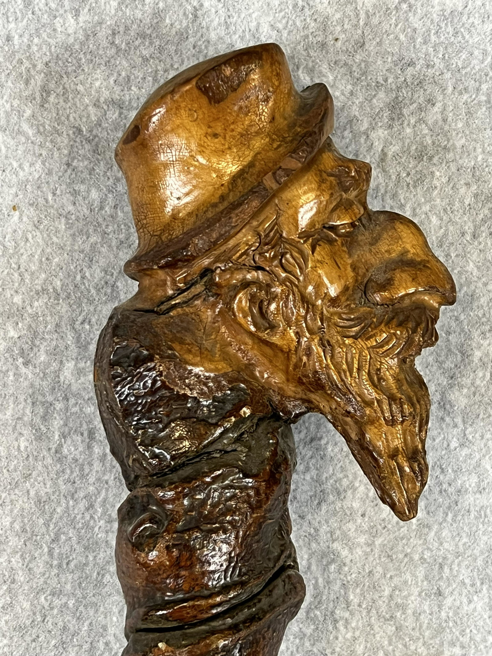 Antique Folk Art Hand Carve Cane Featuring A Old Man With Beard Wearing A Hat: Antique folk art rustic type cane with a large handle hand carved from a tree root into the form of a old man with a beard and wearing a hat. Cane measures approximately 37 1/2" long with a iron ferru